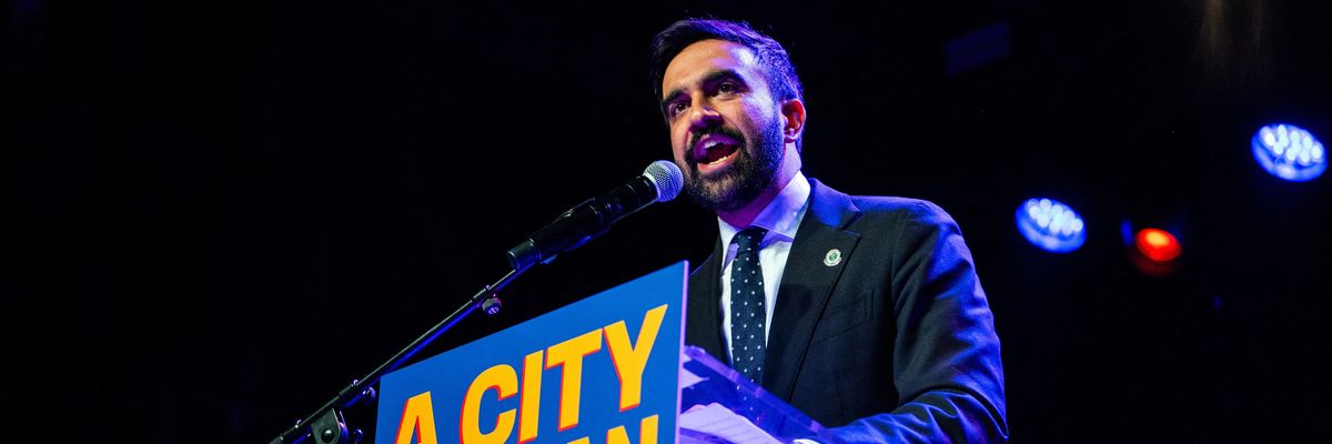 Zohran Mamdani speaks enthusiastically into the microphone at a rally at Brooklyn Steel