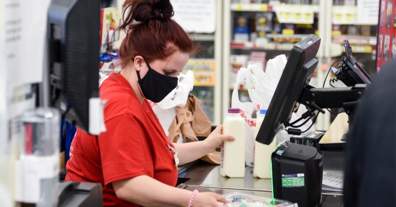 Grocery store employee wearing a mask.