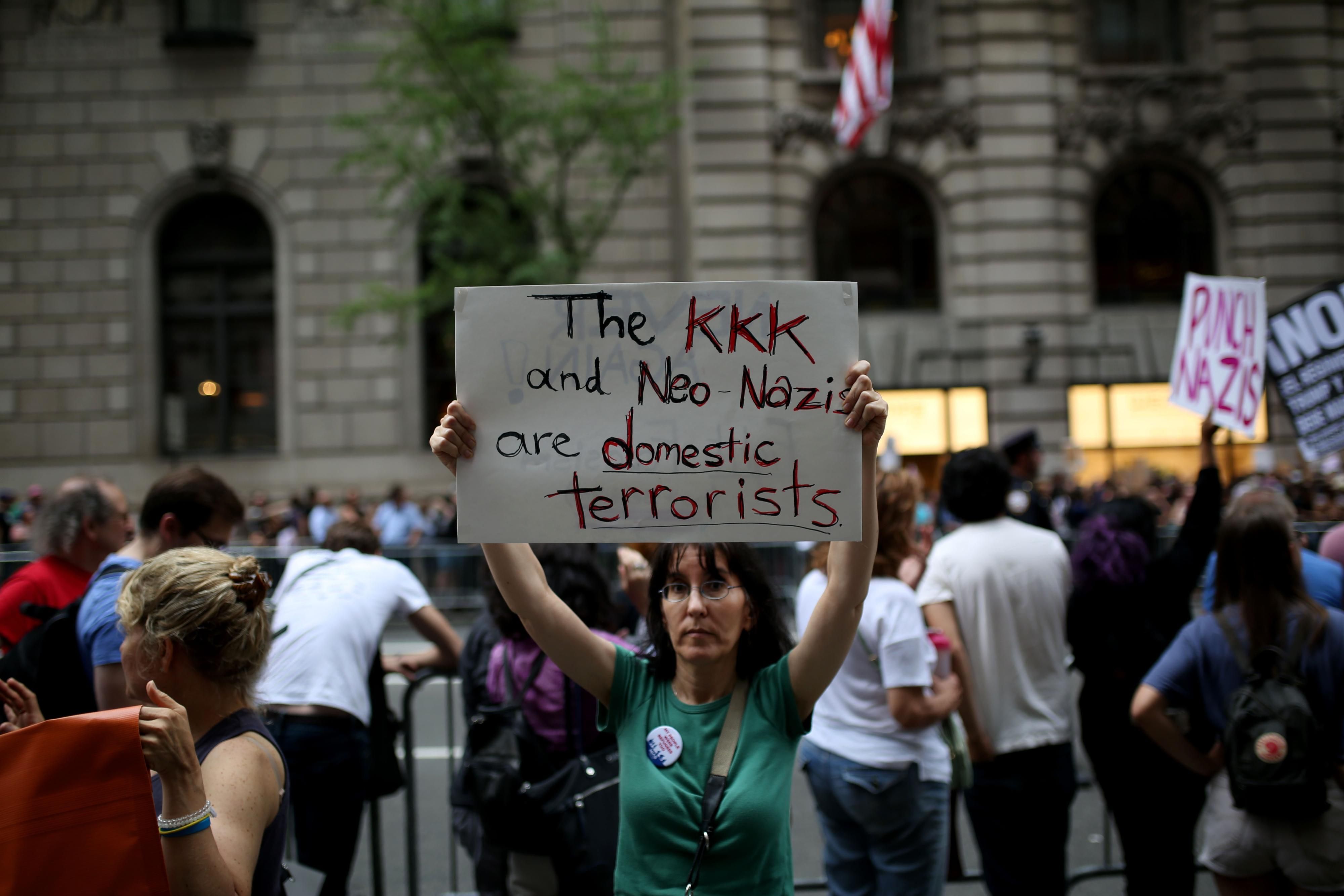 A protester holds a banner reading "The KKK and Neo-Nazis Are Domestic Terrorists" during a rally against then-U.S. President Donald Trump on August 14, 2017 in New York City. (Photo: Mohammed Elshamy/Anadolu Agency via Getty Images)