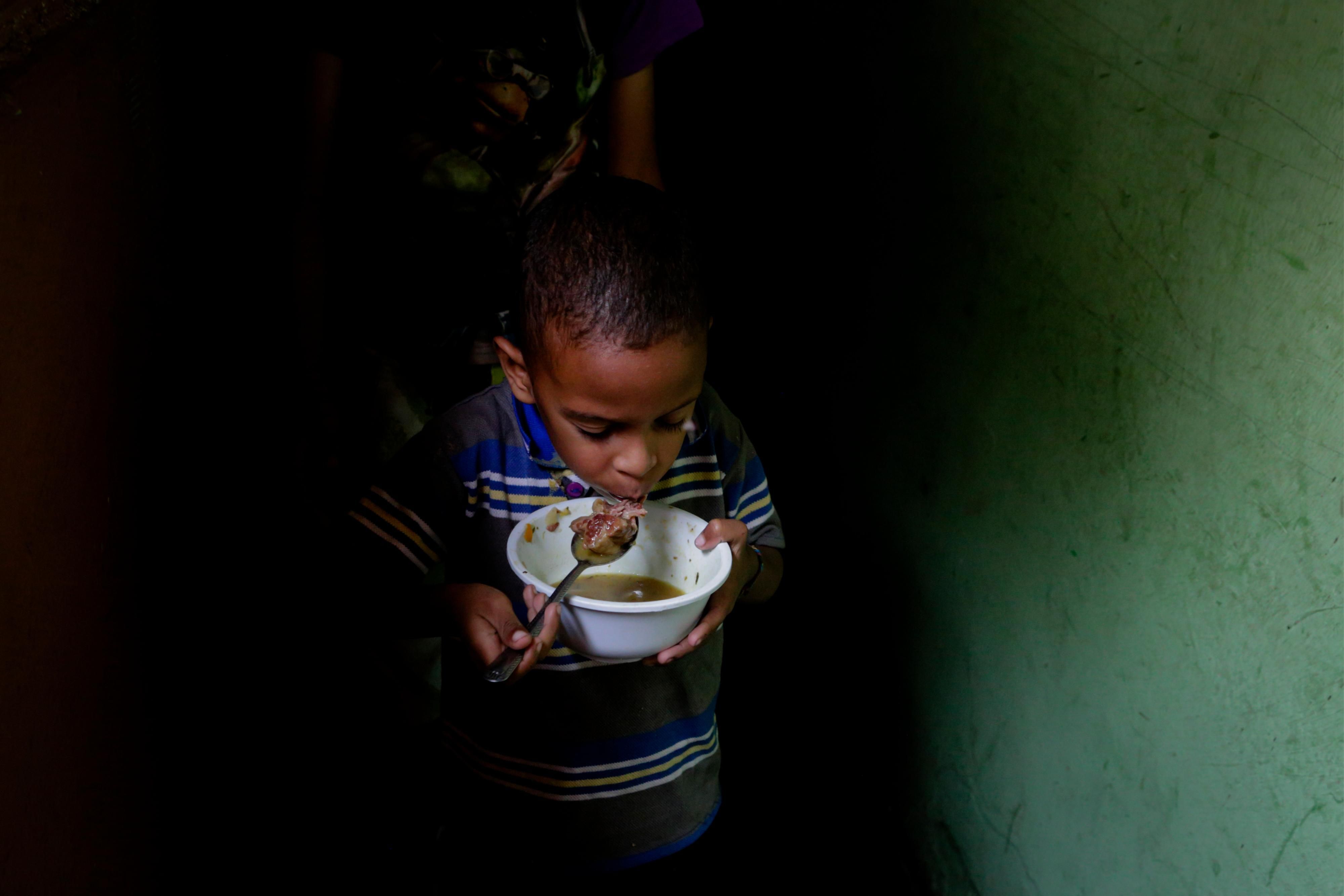 A boy eats soup prepared and donated by a local restaurant on April 12, 2019 in Caracas, Venezuela. (Photo: Eva Marie Uzcategui via Getty Images)