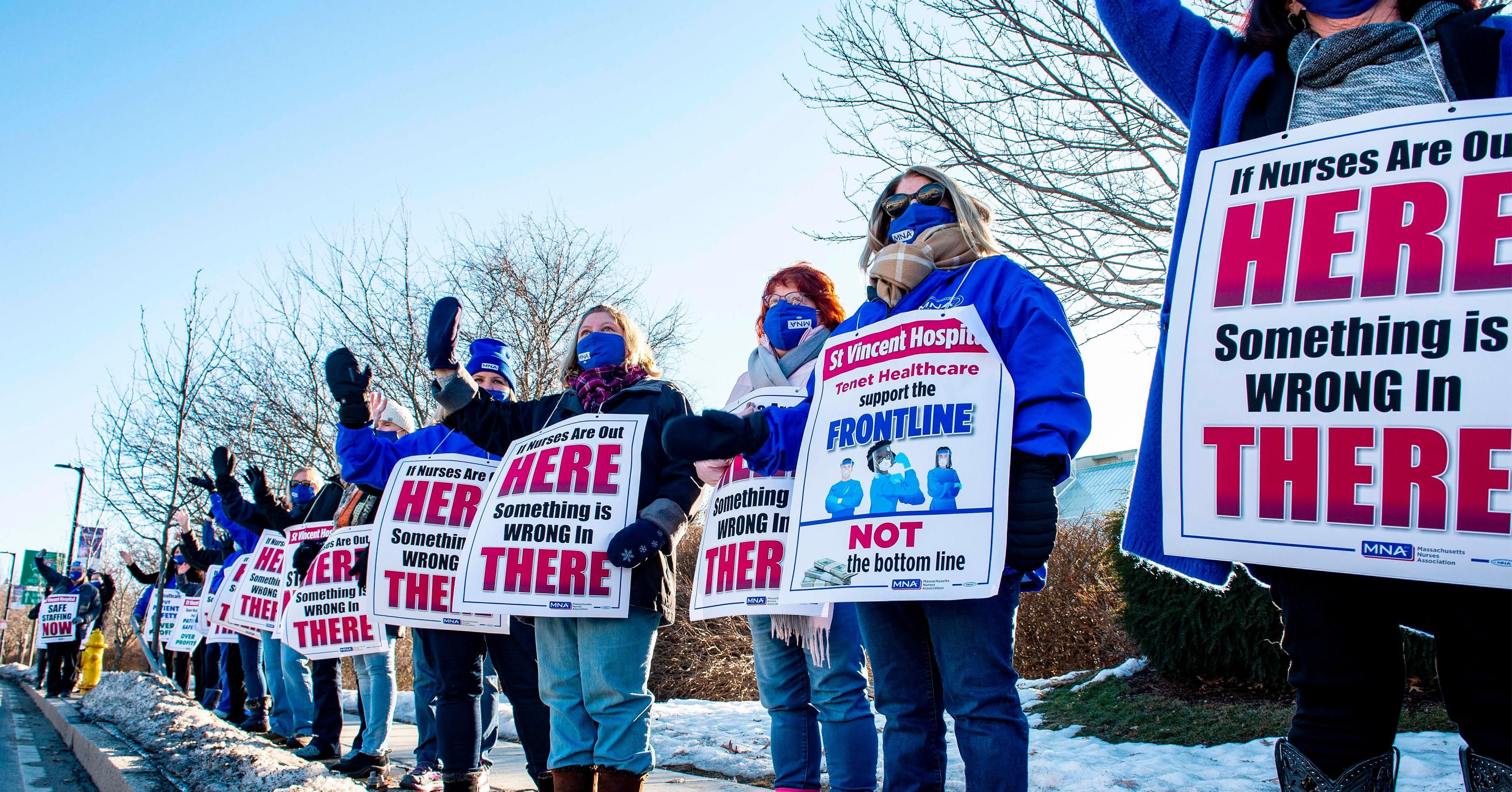 Registered Nurses and supporters stand in a picket line and wave to cars as they drive by outside St. Vincent Hospital in Worcester, Massachusetts on February 24, 2021. - 800 Nurses voted to go on strike starting March 8 after giving the hospital a ten day notice.