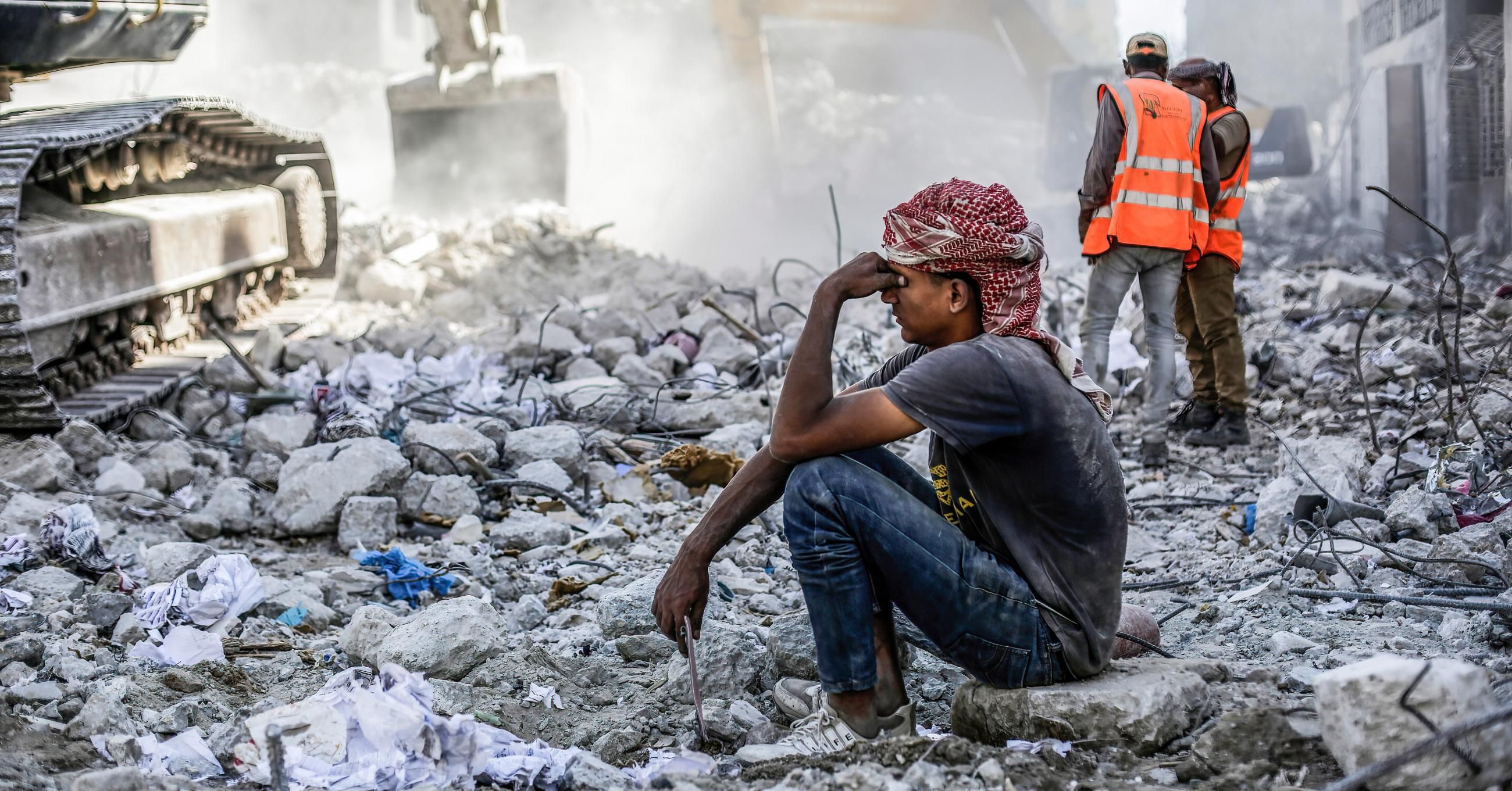 Palestinian man sits in rubble in Gaza