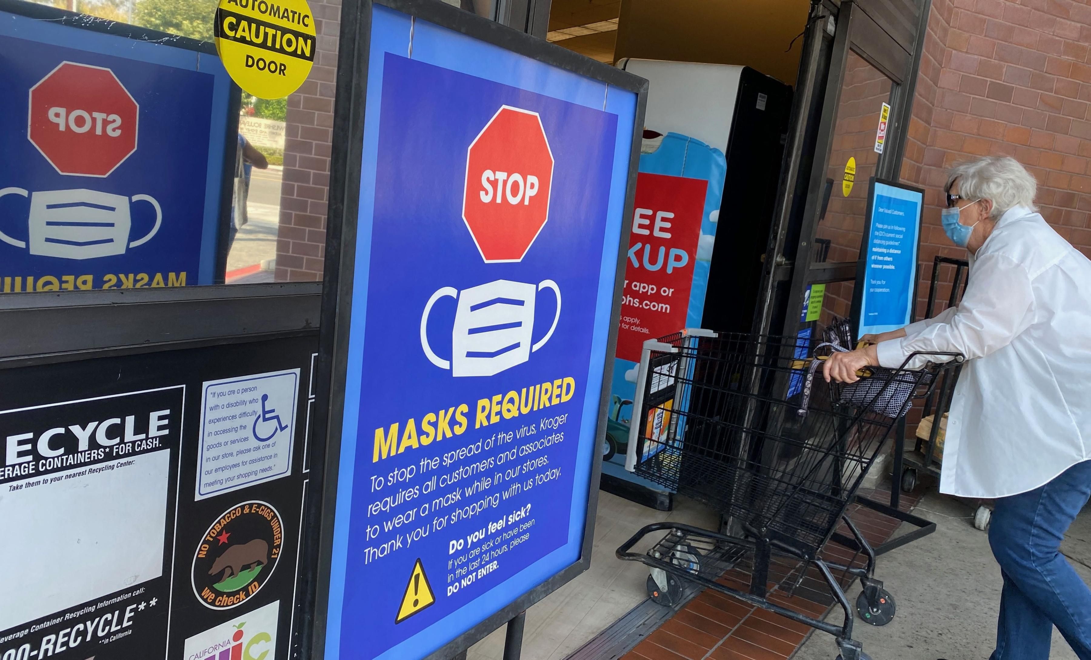 People shop at a store enforcing mask-wearing requirements