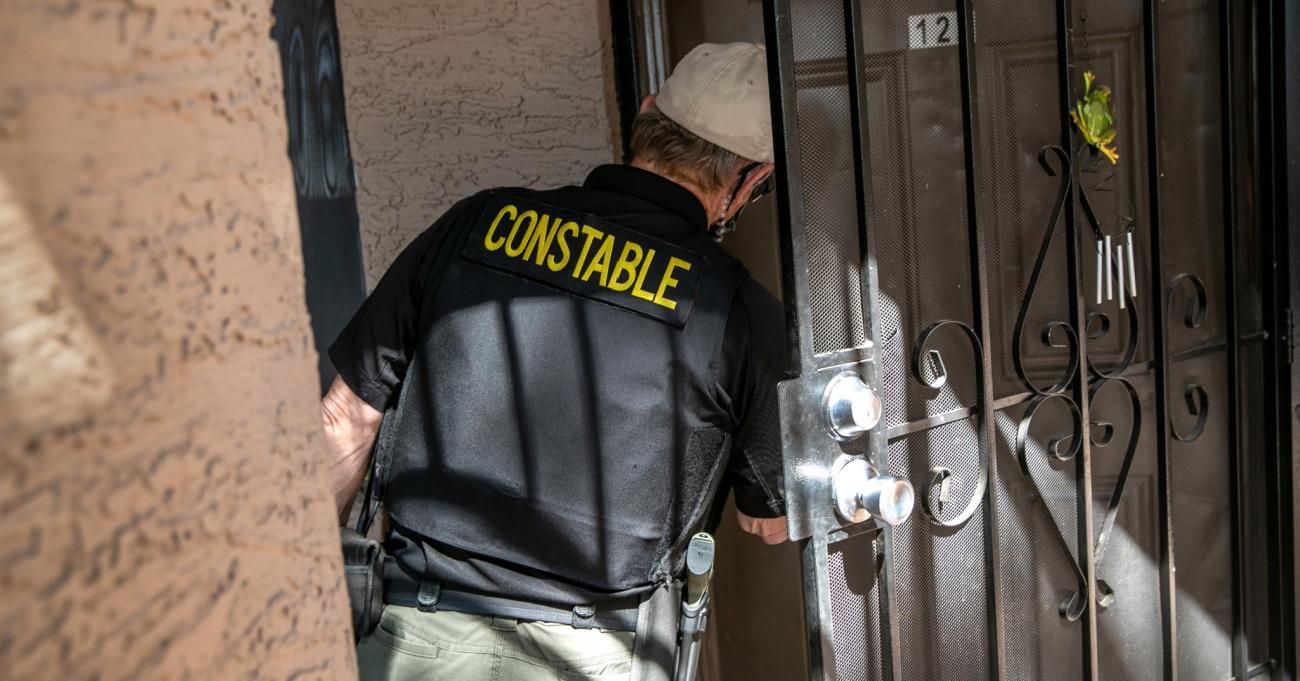 A constable in Maricopa County, Arizona serves an eviction notice.