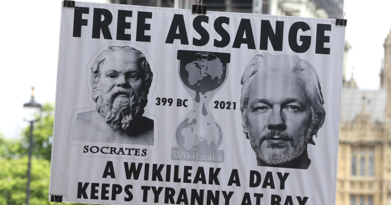 Supporters carry signs calling for release of Julian Assange.