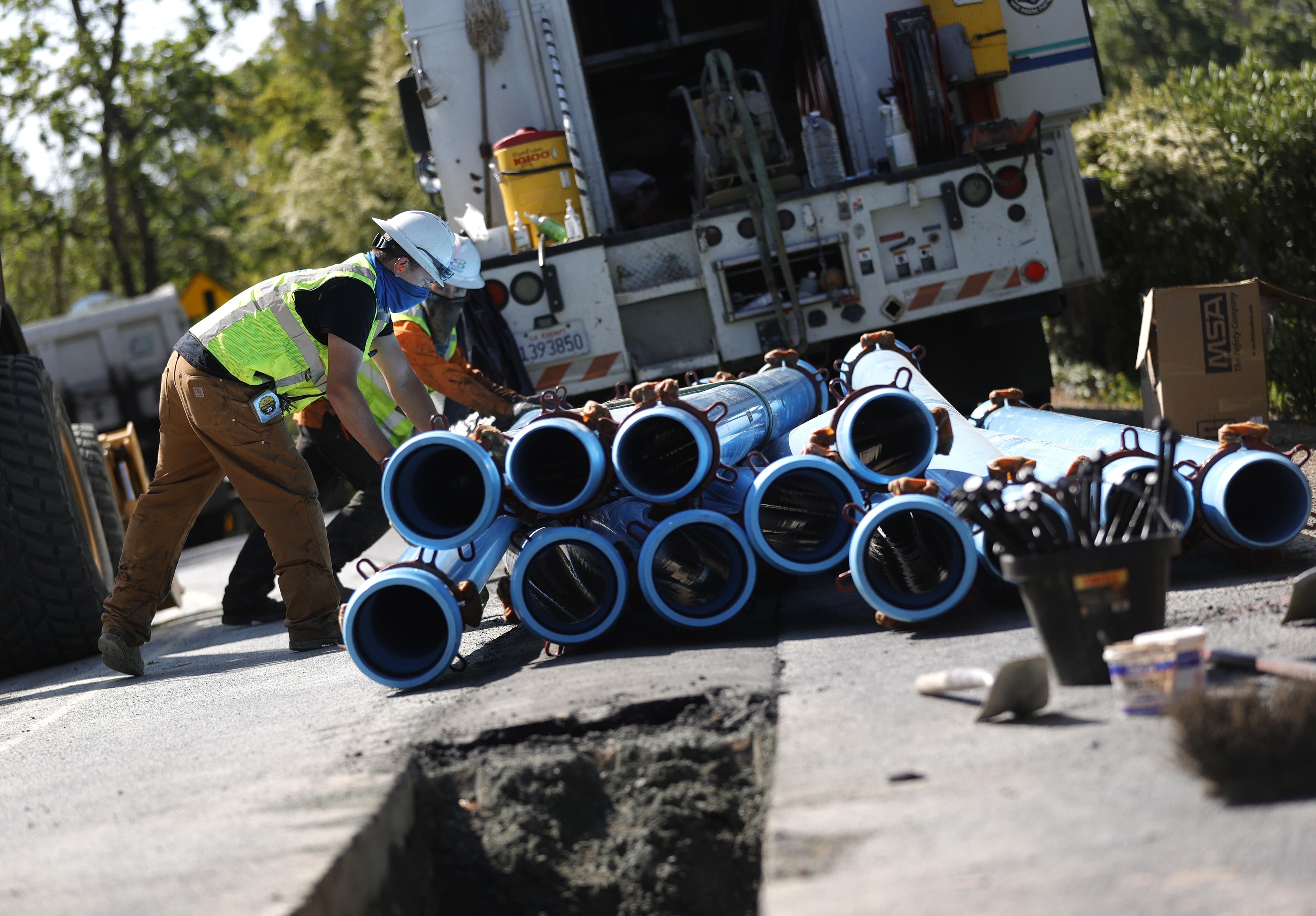 workers stack water pipes