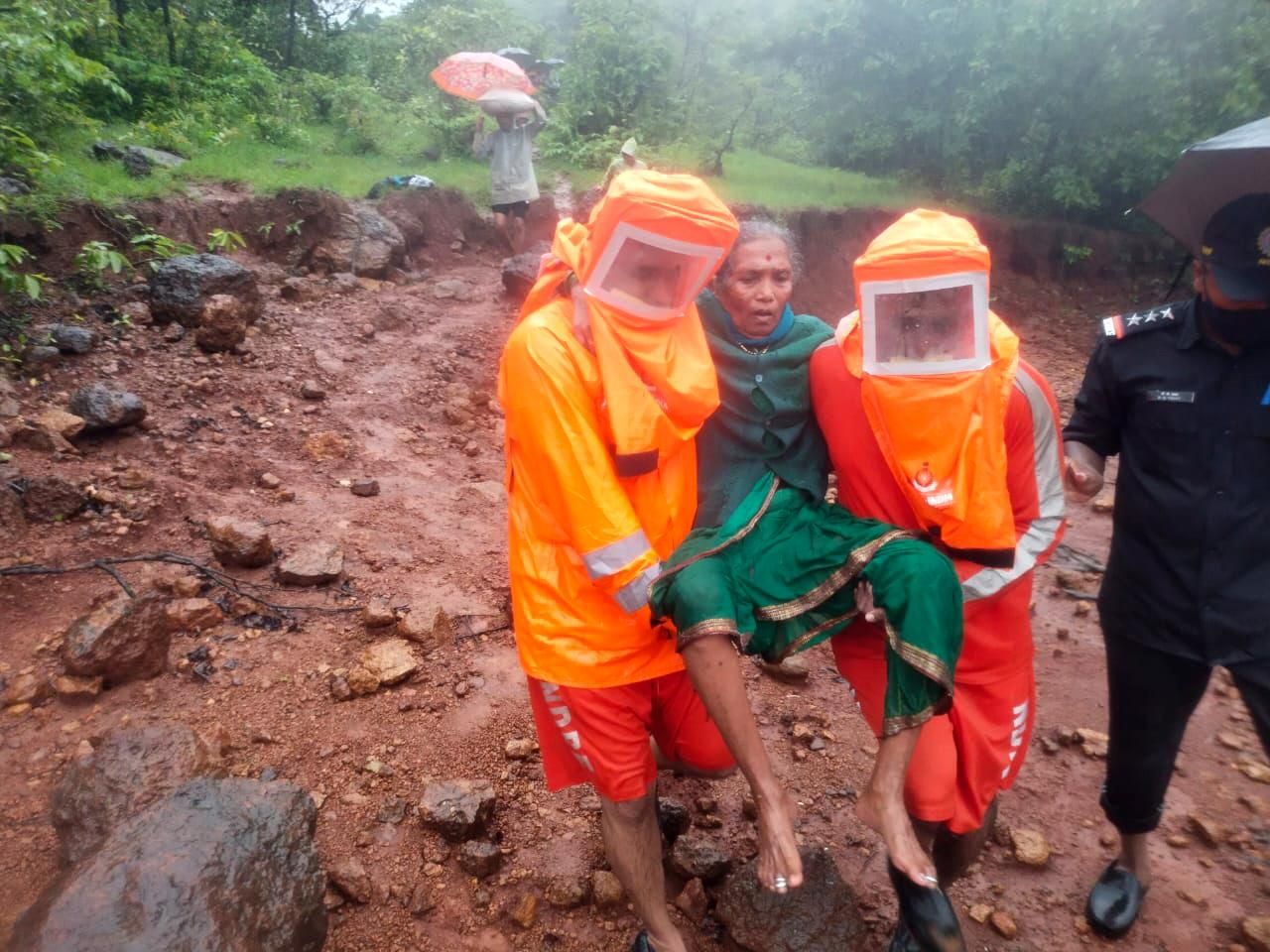 National Disaster Response Force personnel carry a woman in Chikhali village on July 23, 2021, during a rescue operation after heavy monsoon rains in India triggered deadly landslides in the western state of Maharashtra. (Photo: National Disaster Response Force/Handout/Anadolu Agency via Getty Images)