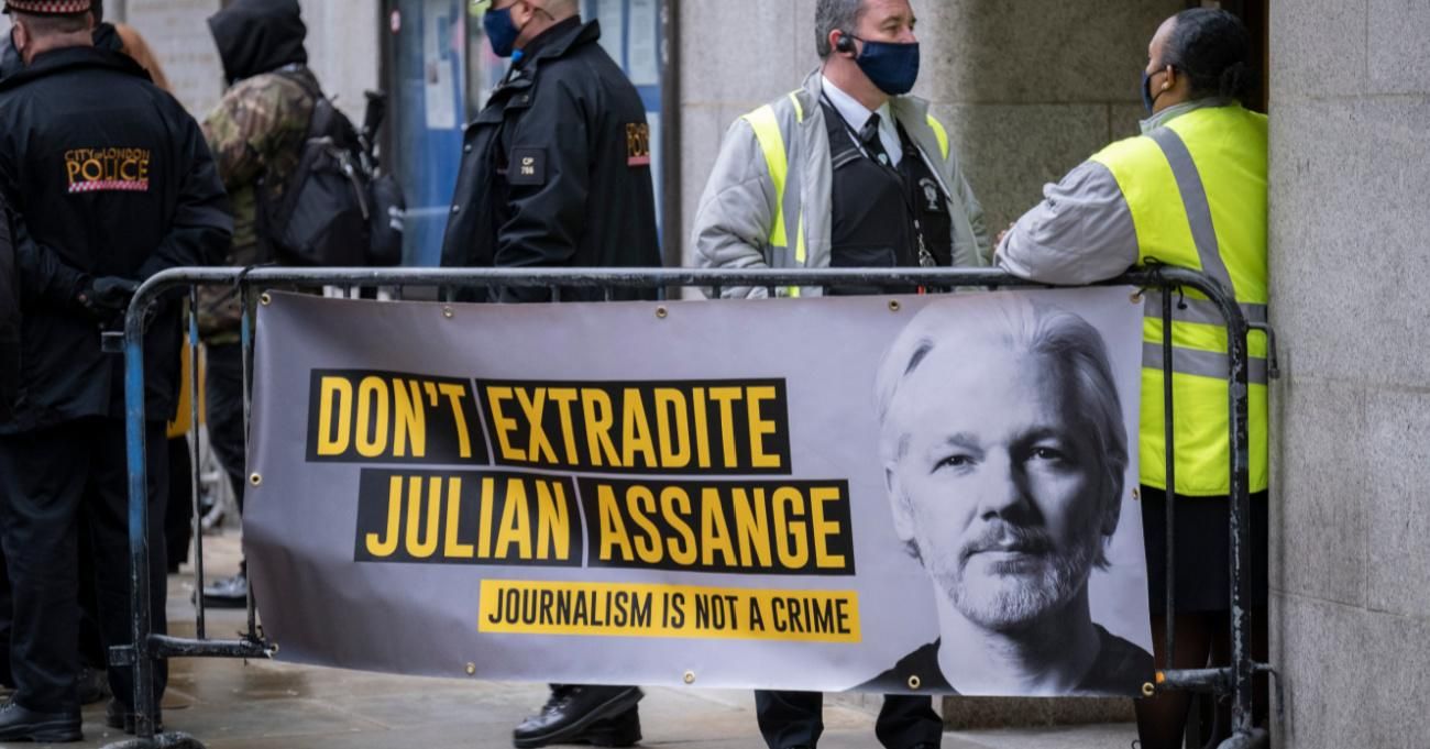 Supporters carry signs calling for release of Julian Assange.