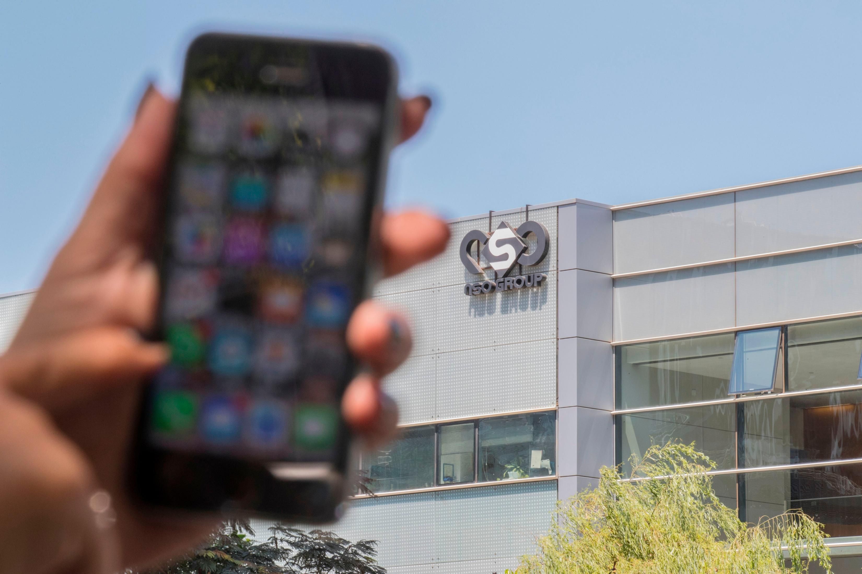 An Israeli woman uses her iPhone in front of the building housing the Israeli NSO group, on August 28, 2016, in Herzliya, near Tel Aviv.&nbsp;(Photo: Jack Guez/AFP via Getty Images)