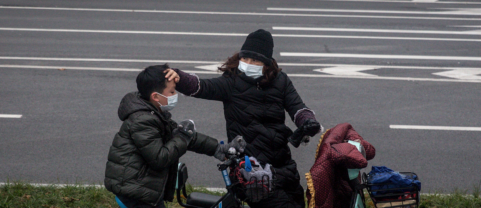 A woman checks her son's forehead on January 27, 2020 in Wuhan, China. 