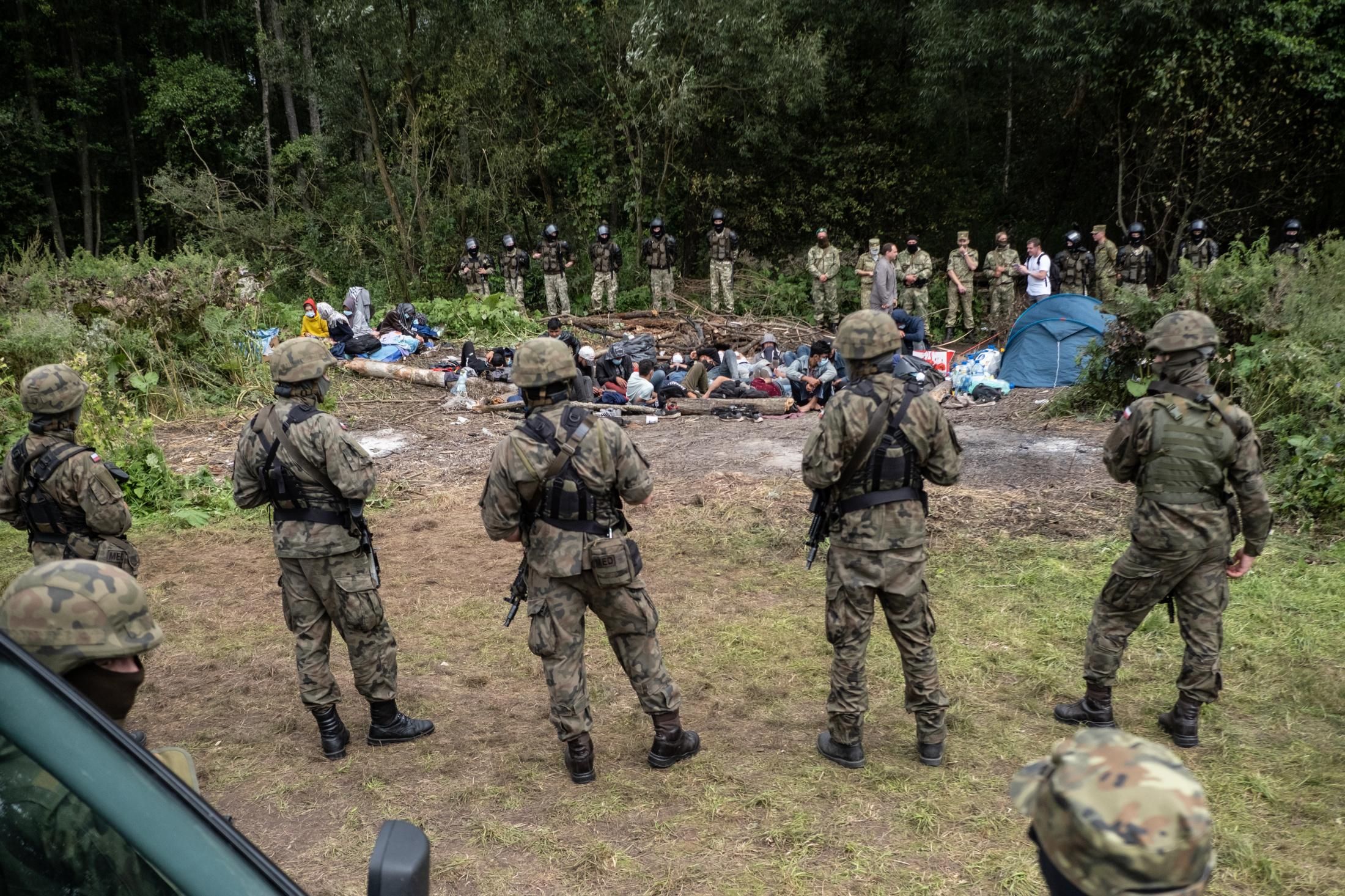Afghan refugees are surrounded by security forces at the Poland-Belarus border on August 26, 2021. The group of migrants from Afghanistan has been stuck at the E.U.'s eastern border for several weeks as Belarus and Poland both refuse to let them in. (Photo: Maciej Moskwa/NurPhoto via Getty Images)