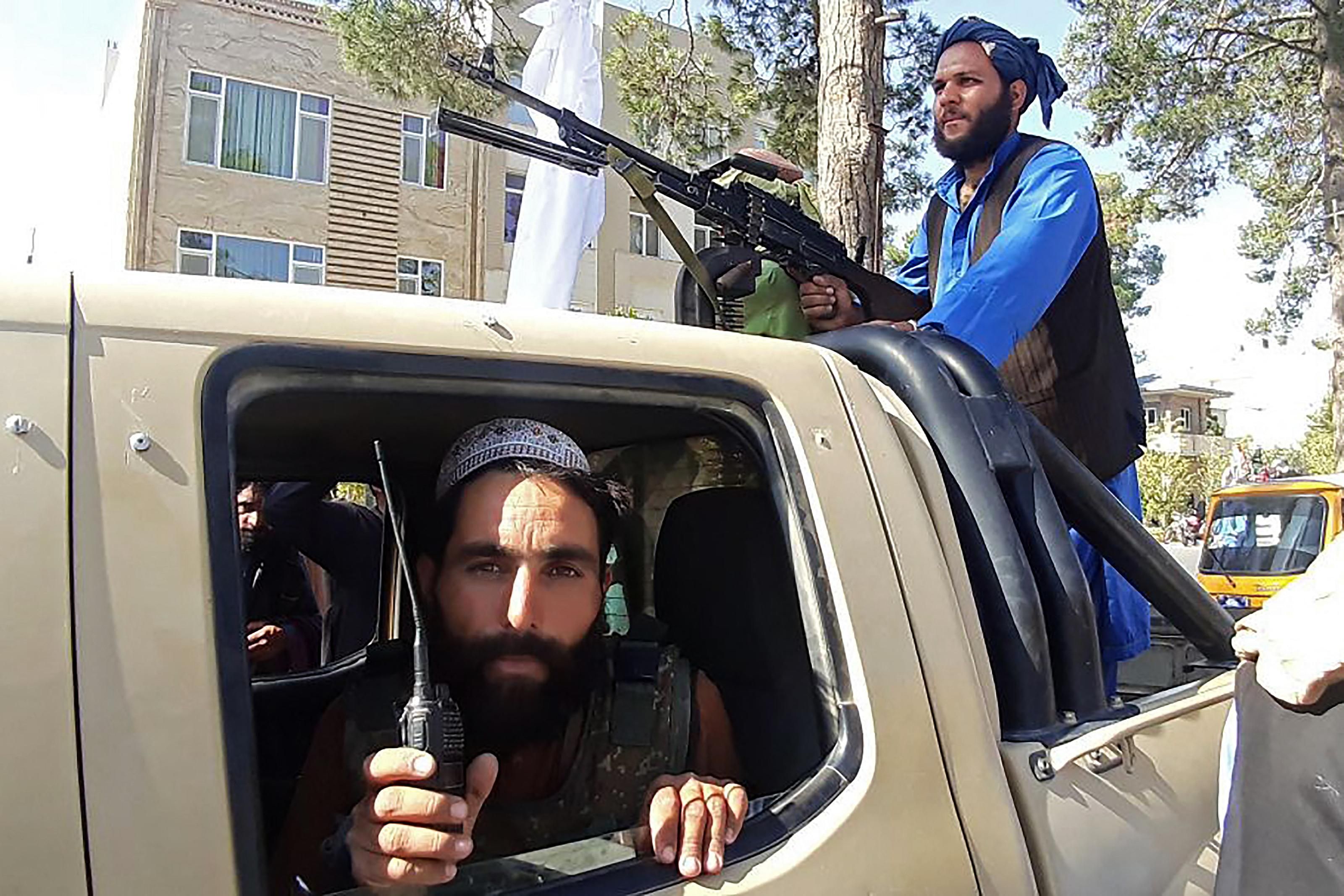 Taliban fighters in a vehicle along the roadside in Herat