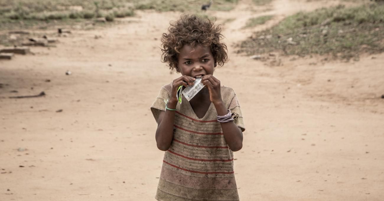 A child in Madagascar eats a nutritional supplement distributed by an NGO.