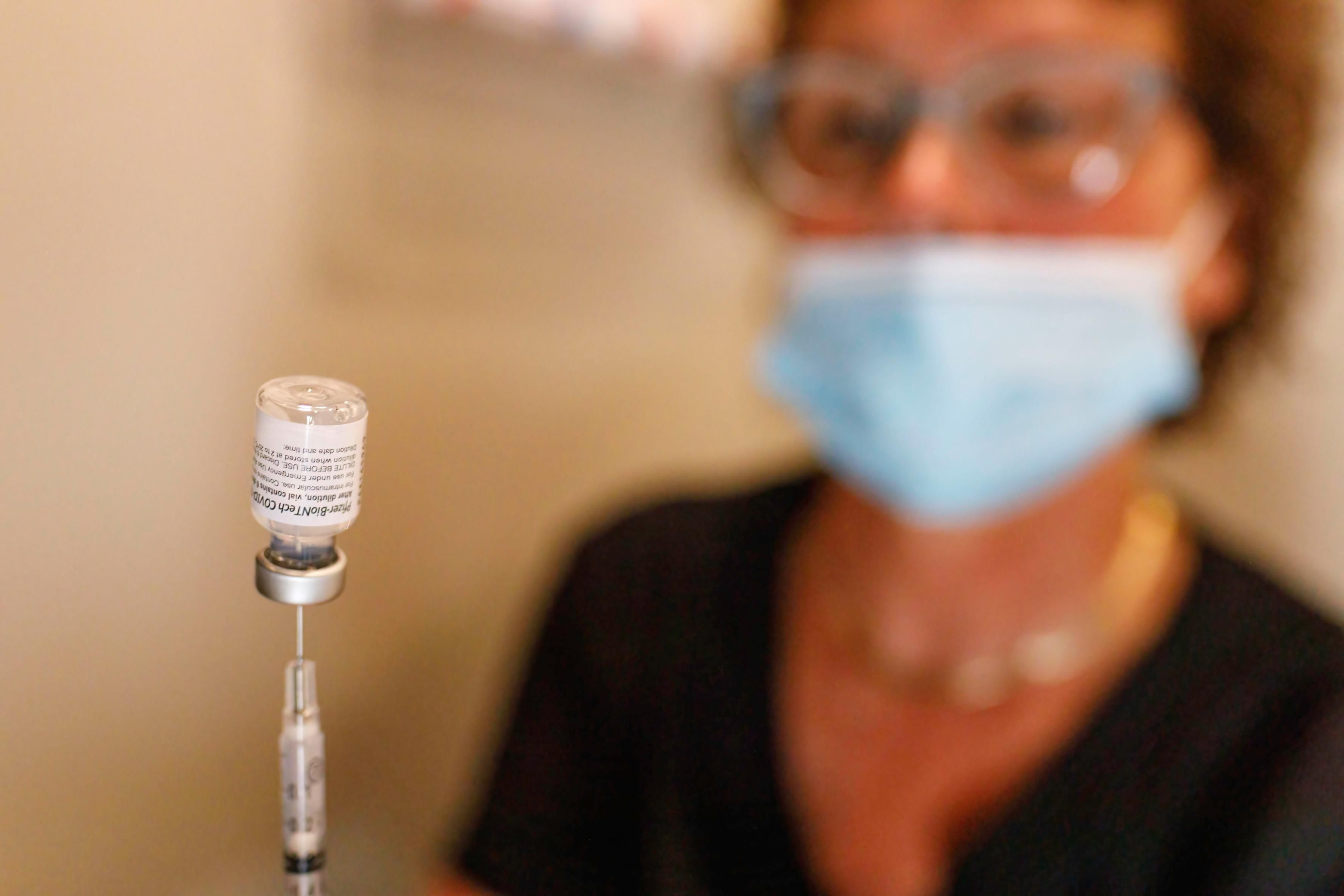 Nurse holds vial of Pfizer vaccine 