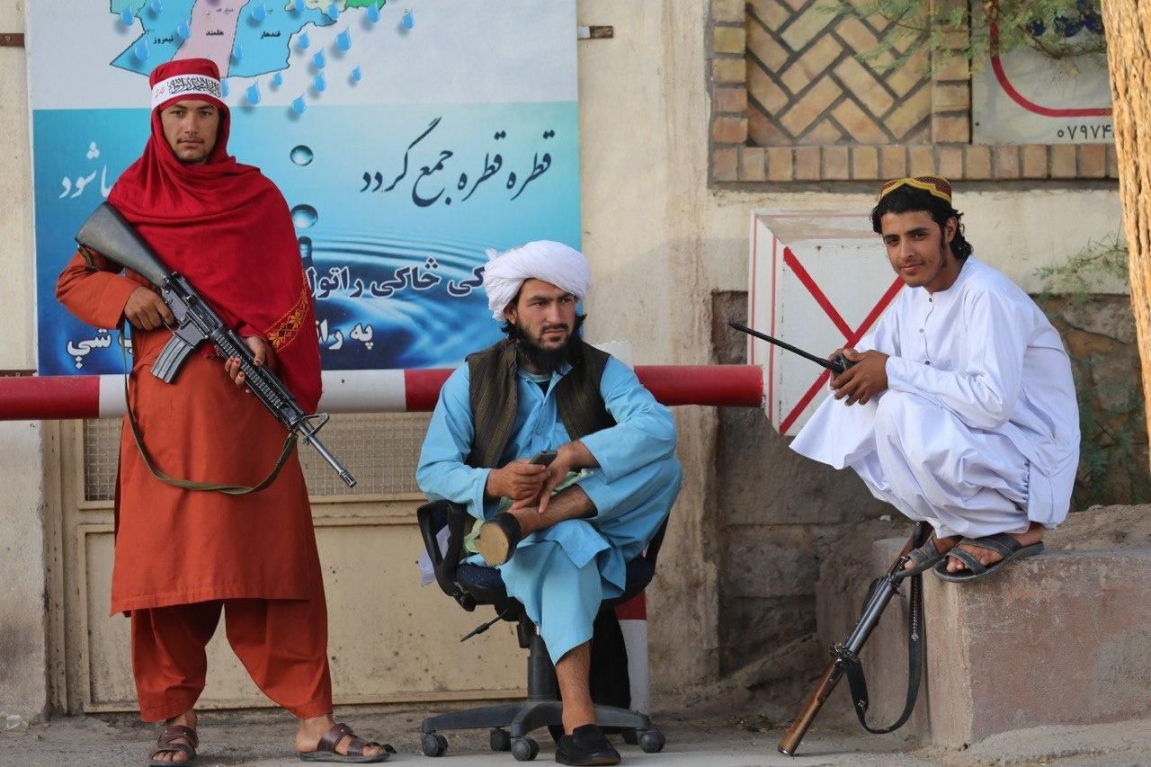 Taliban fighters hold weapons