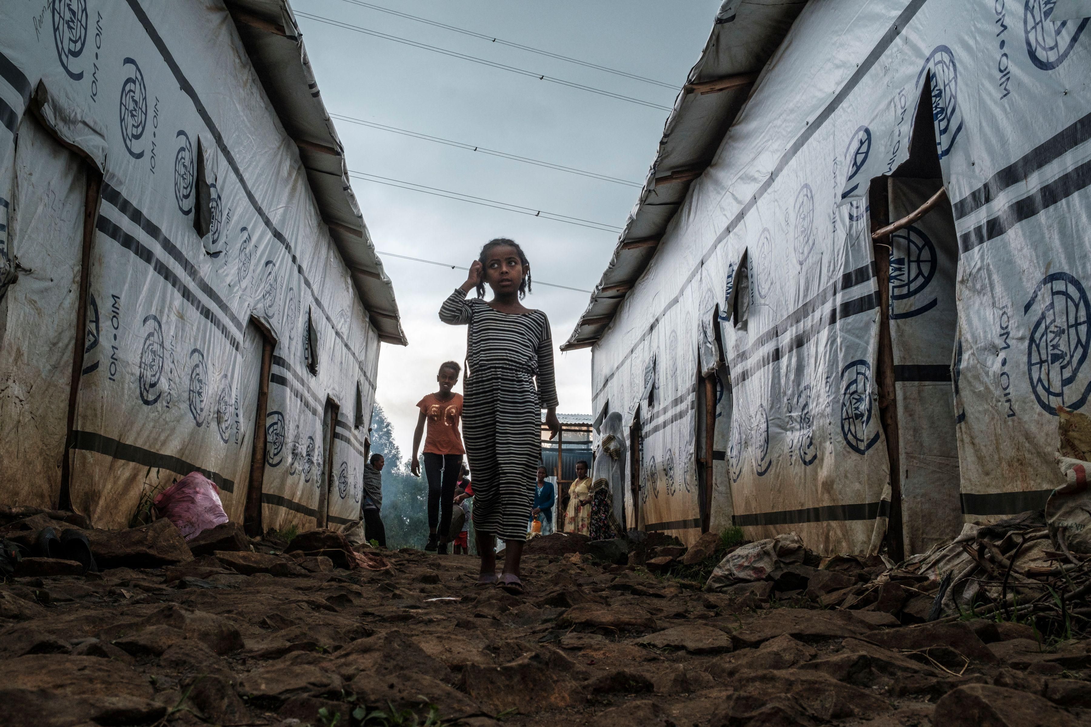 Internally displaced children run in an alley of a camp in the town of Azezo, Ethiopia