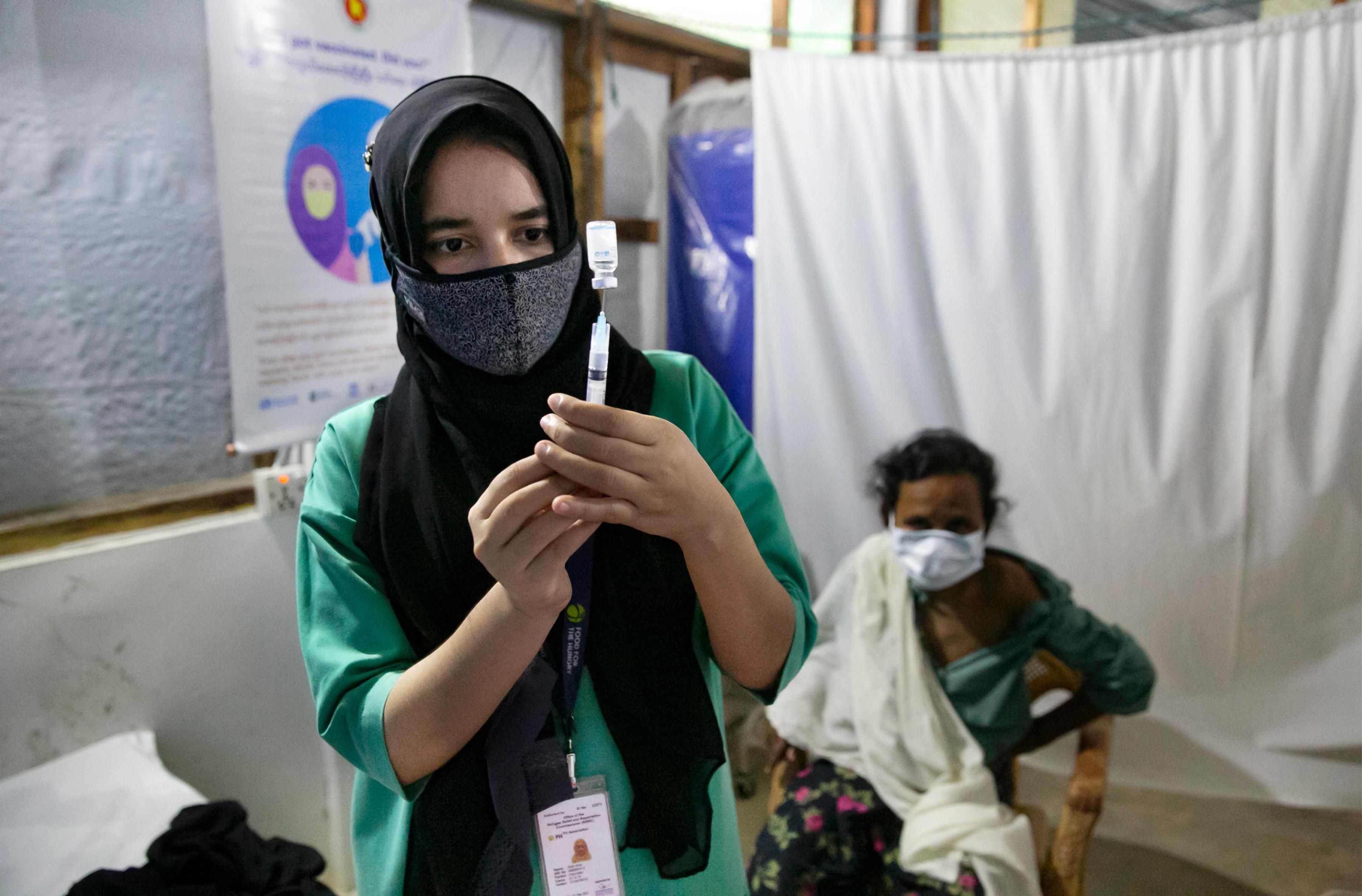 A nurse prepares a coronavirus vaccine dose for a patient