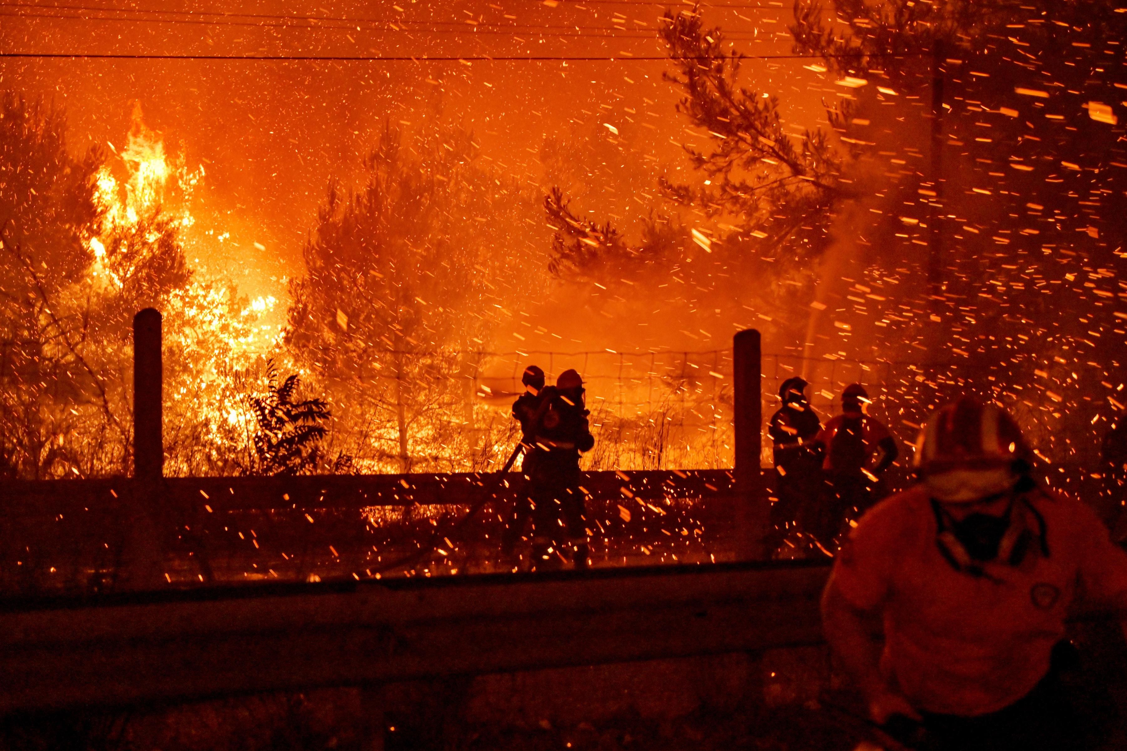 Firefighters combat a wildfire in Athens, Greece