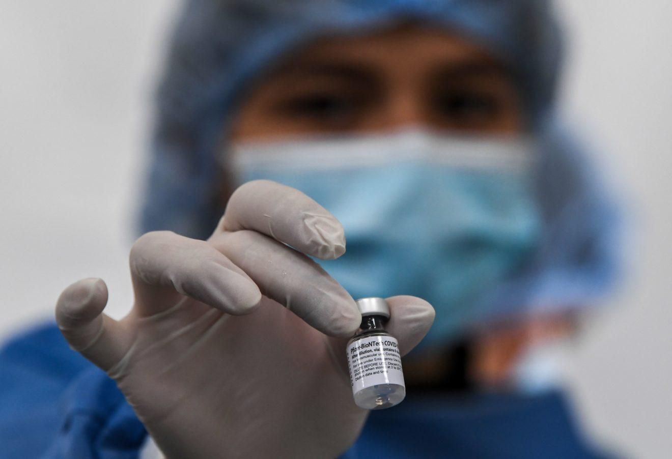 A nurse holds a vial of the Pfizer-BioNTech vaccine