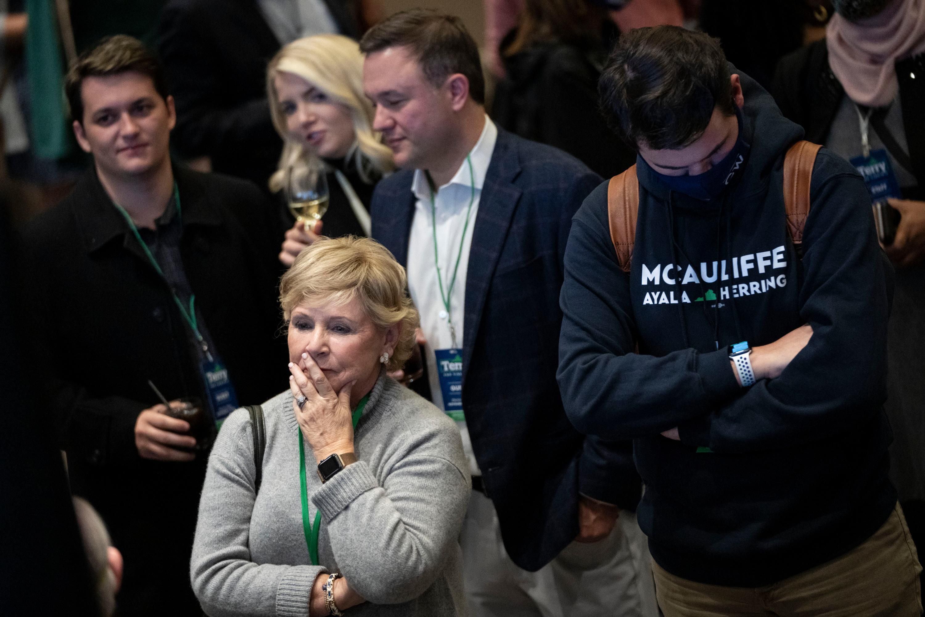 Supporters of Terry McAuliffe look on