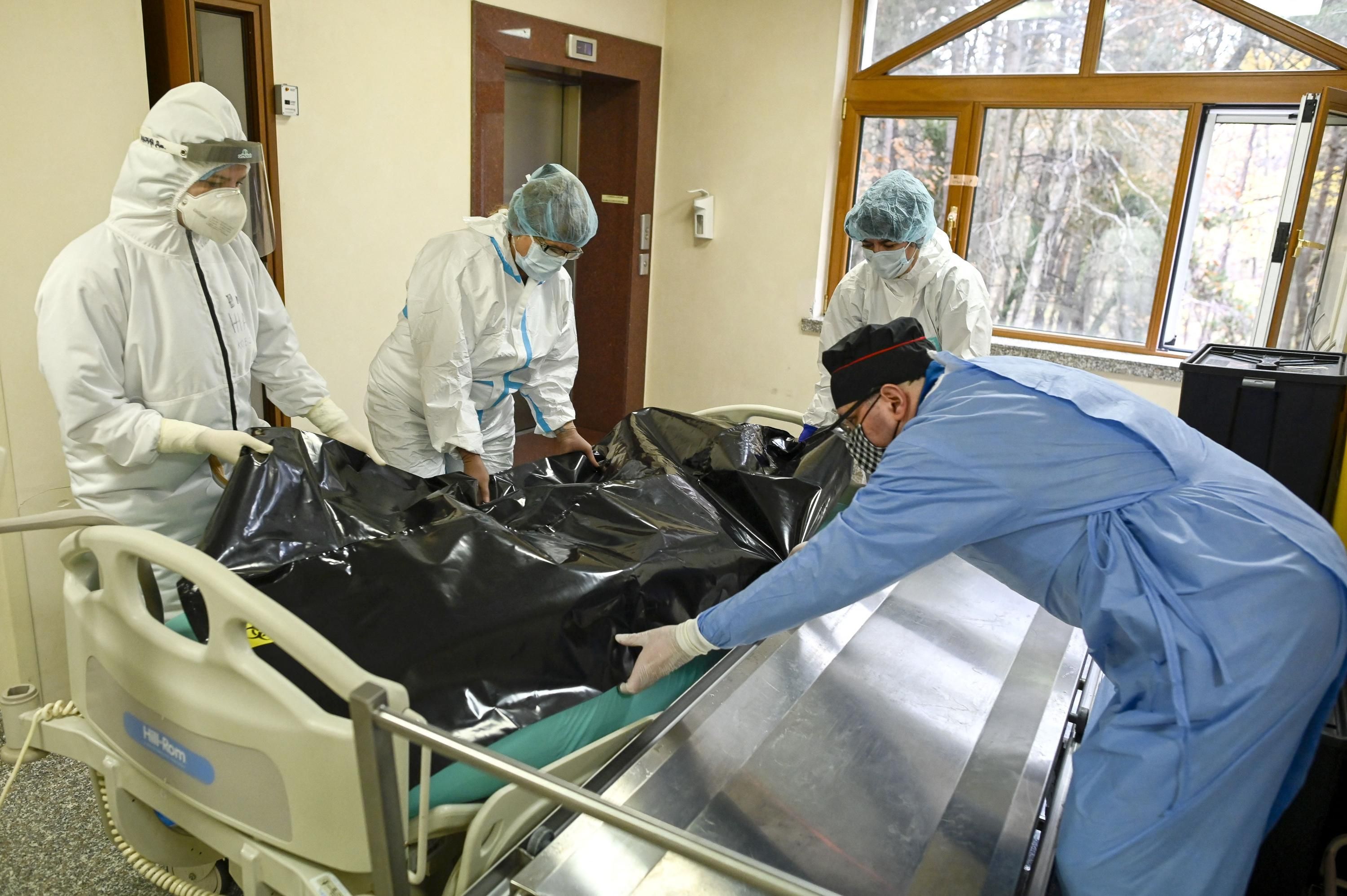 Healthcare workers move the bodybag of a Covid-19 victim.