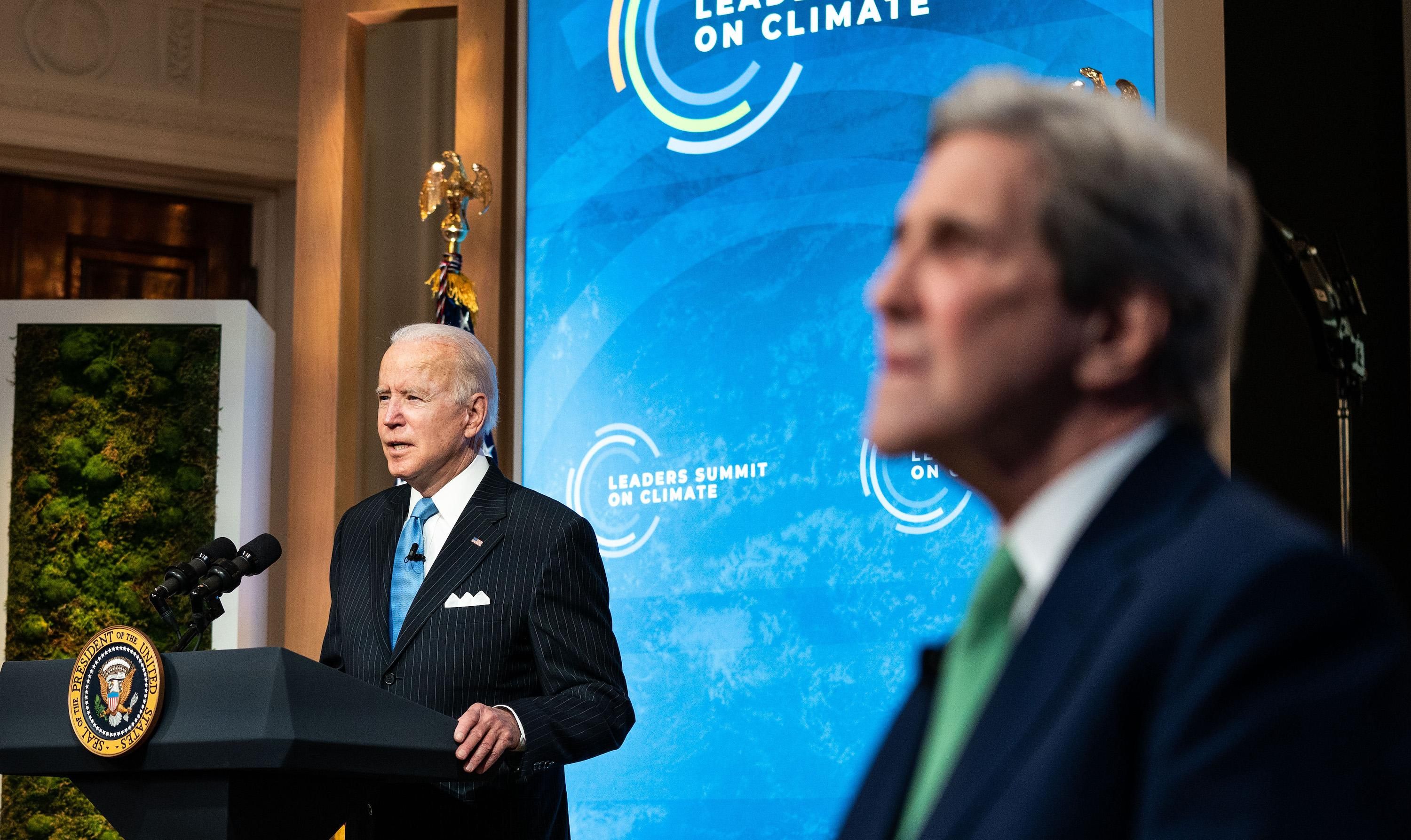 President Biden speaks as climate envoy John Kerry listens