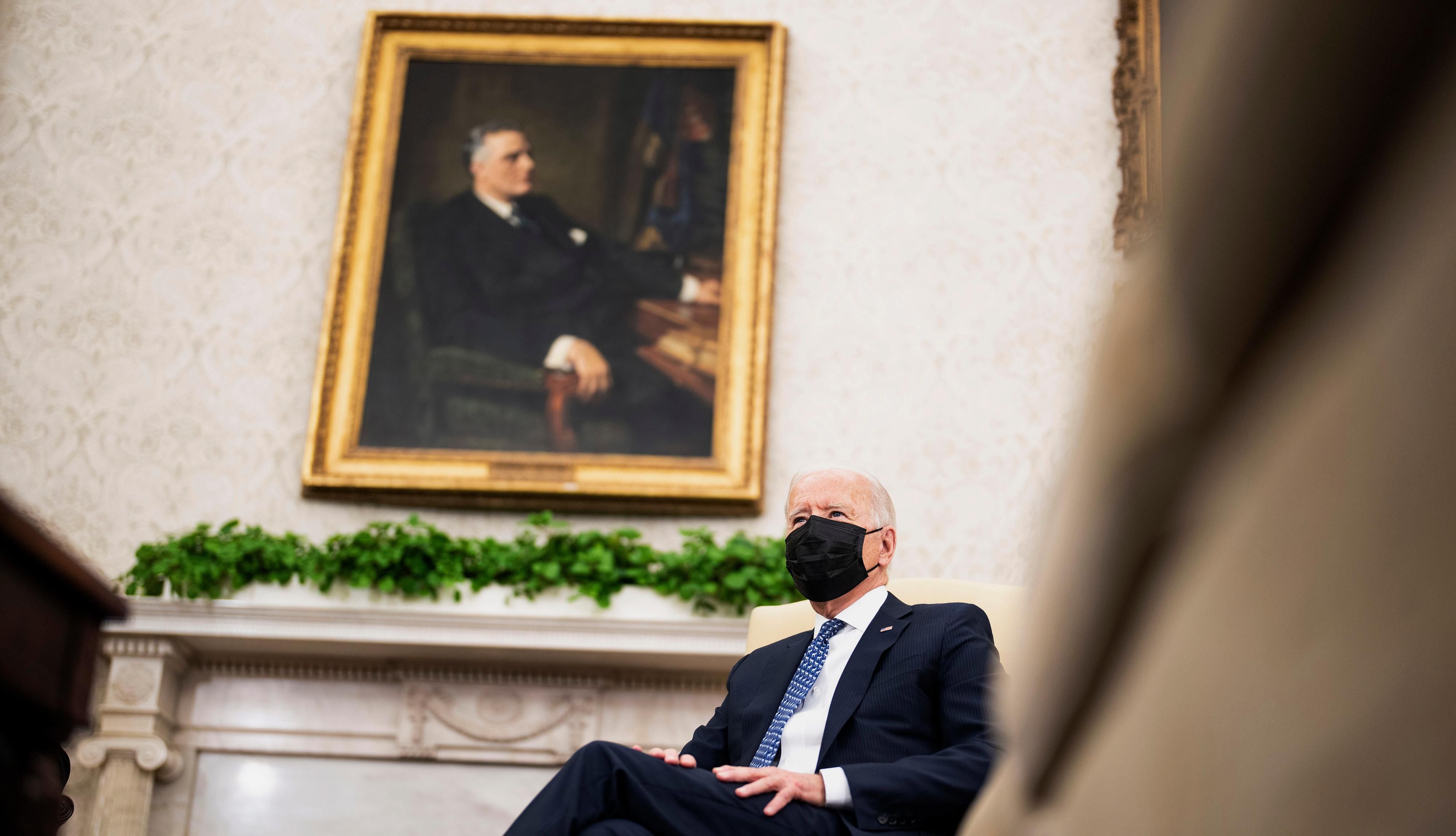 Joe Biden sitting beneath portrait of FDR