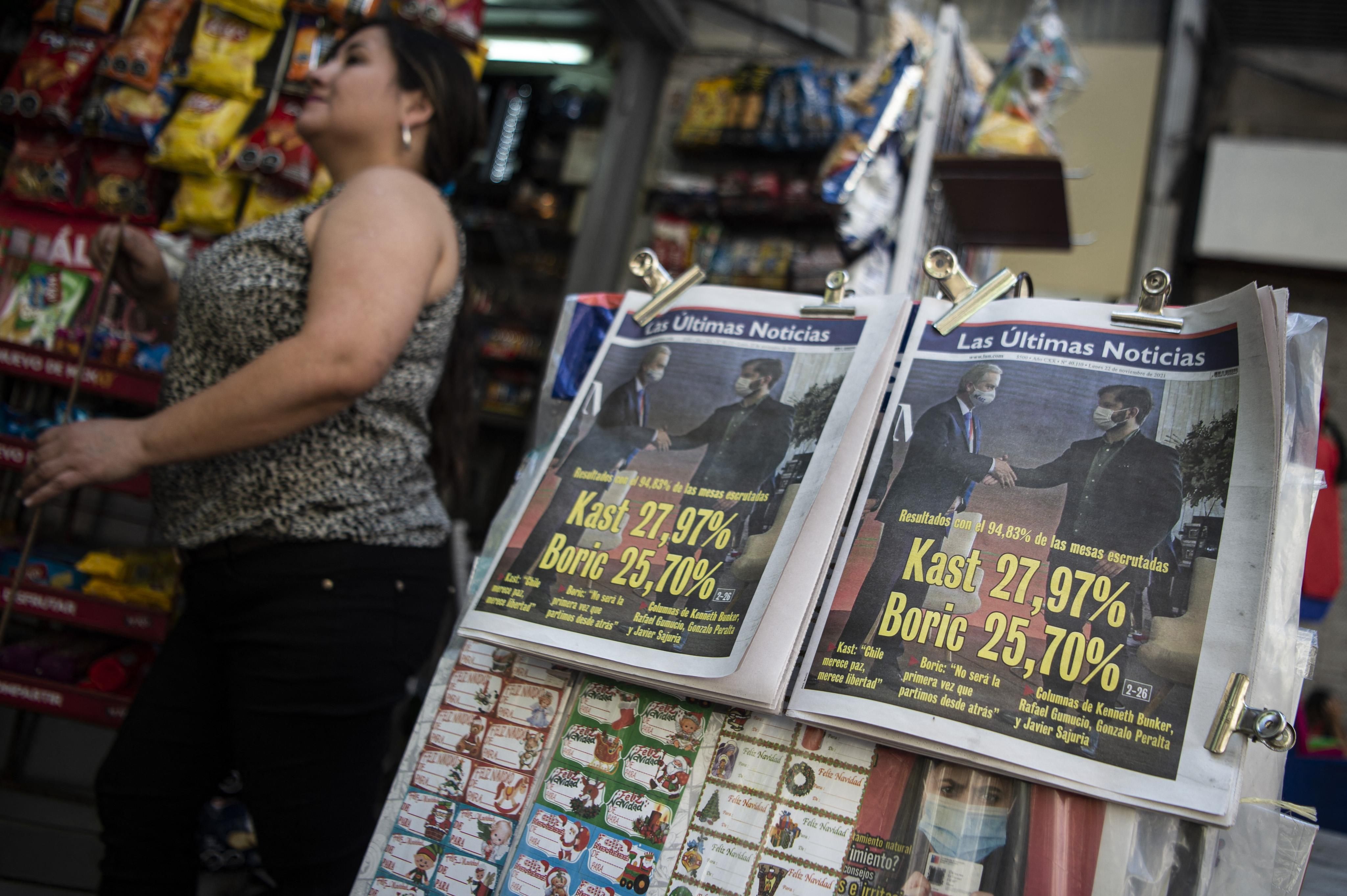 Newspapers showing the results of the first round of the Chilean presidential election are displayed in Santiago on November 22, 2021