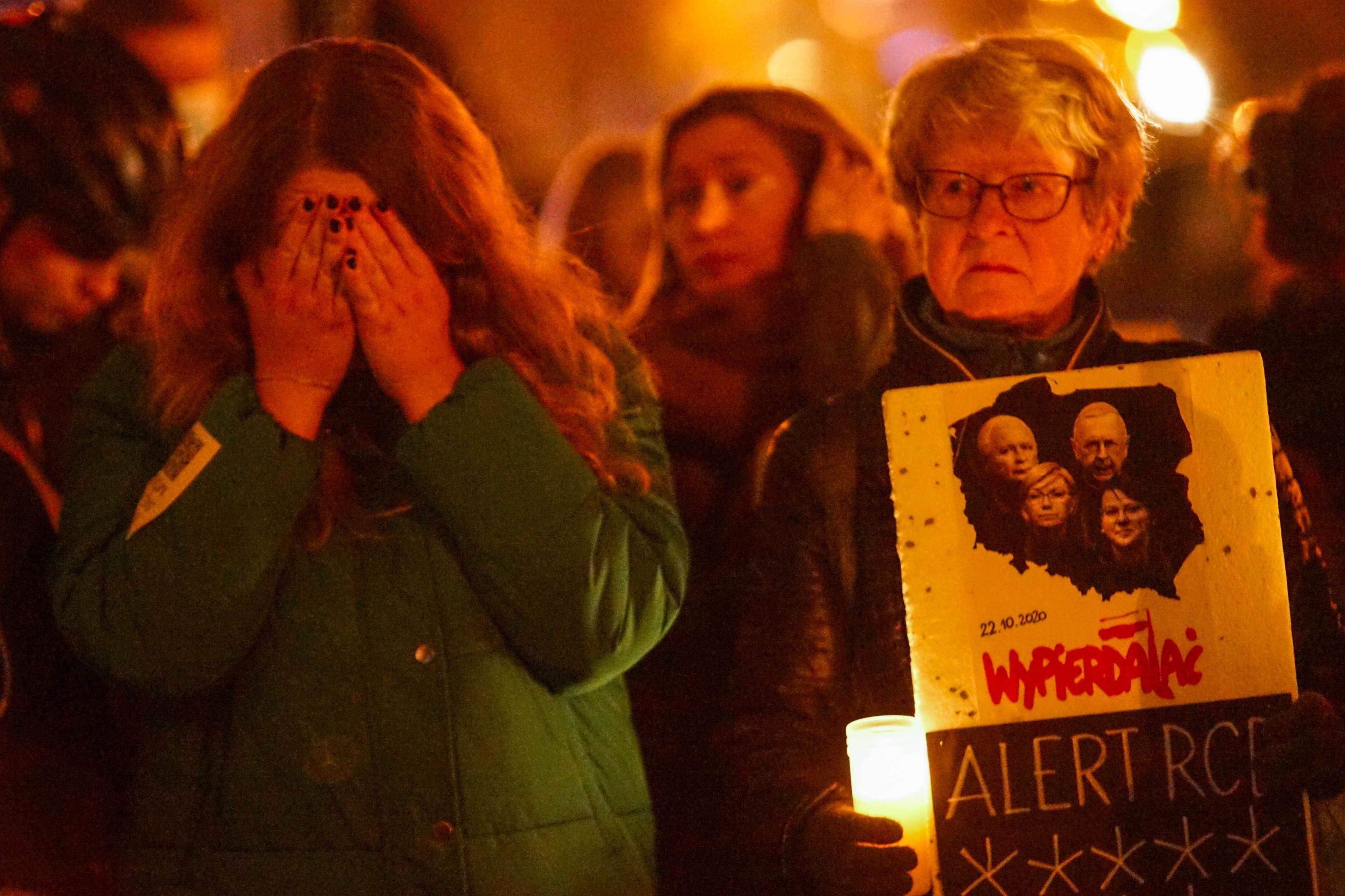 Demonstrators attend a vigil in Poland for a woman who died after doctors refused to give her an abortion