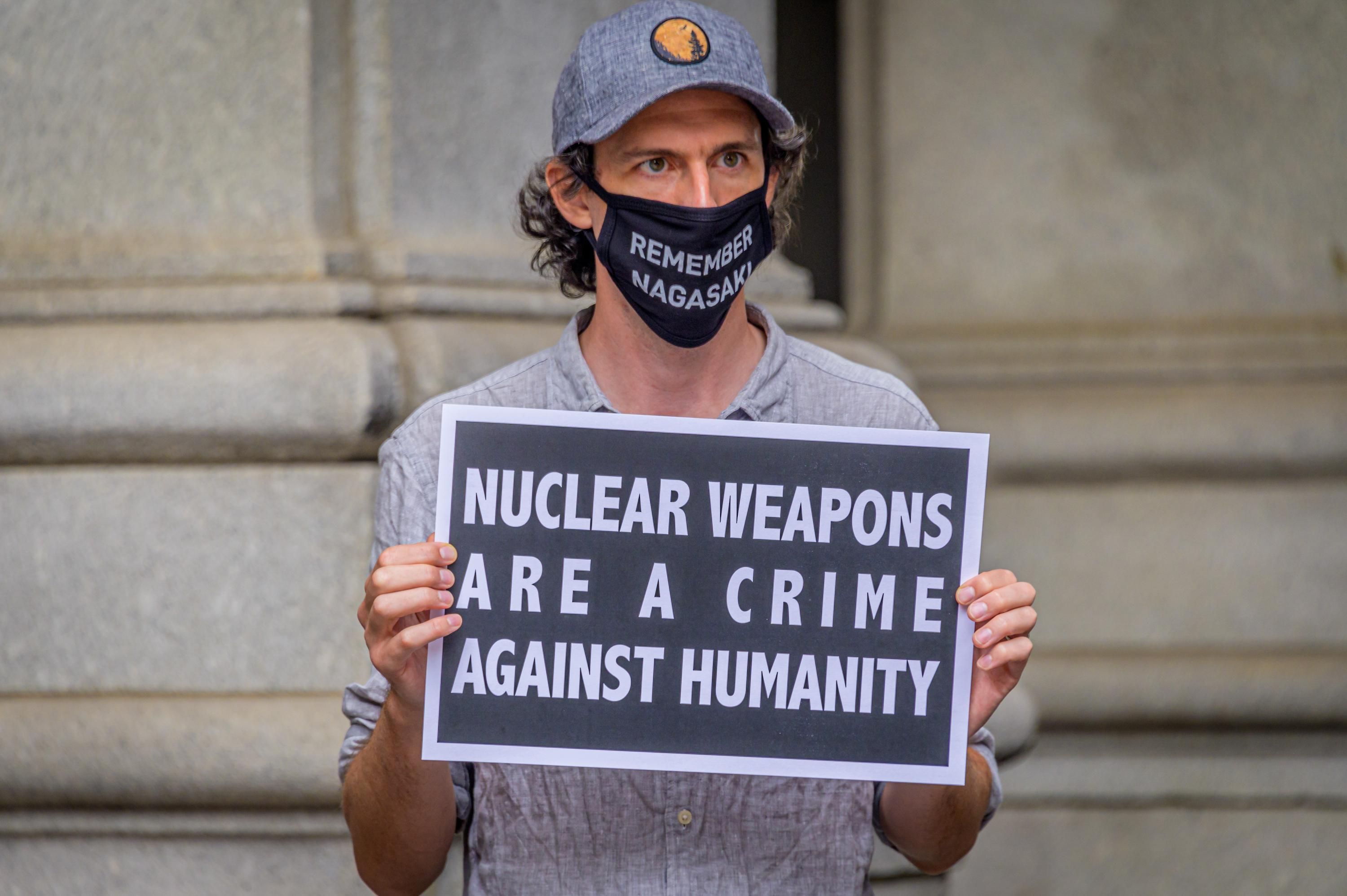 A participant holds a sign during a rally outside the David N. Dinkins Municipal Building in Manhattan on the 75th anniversary of the bombing of the city of Hiroshima