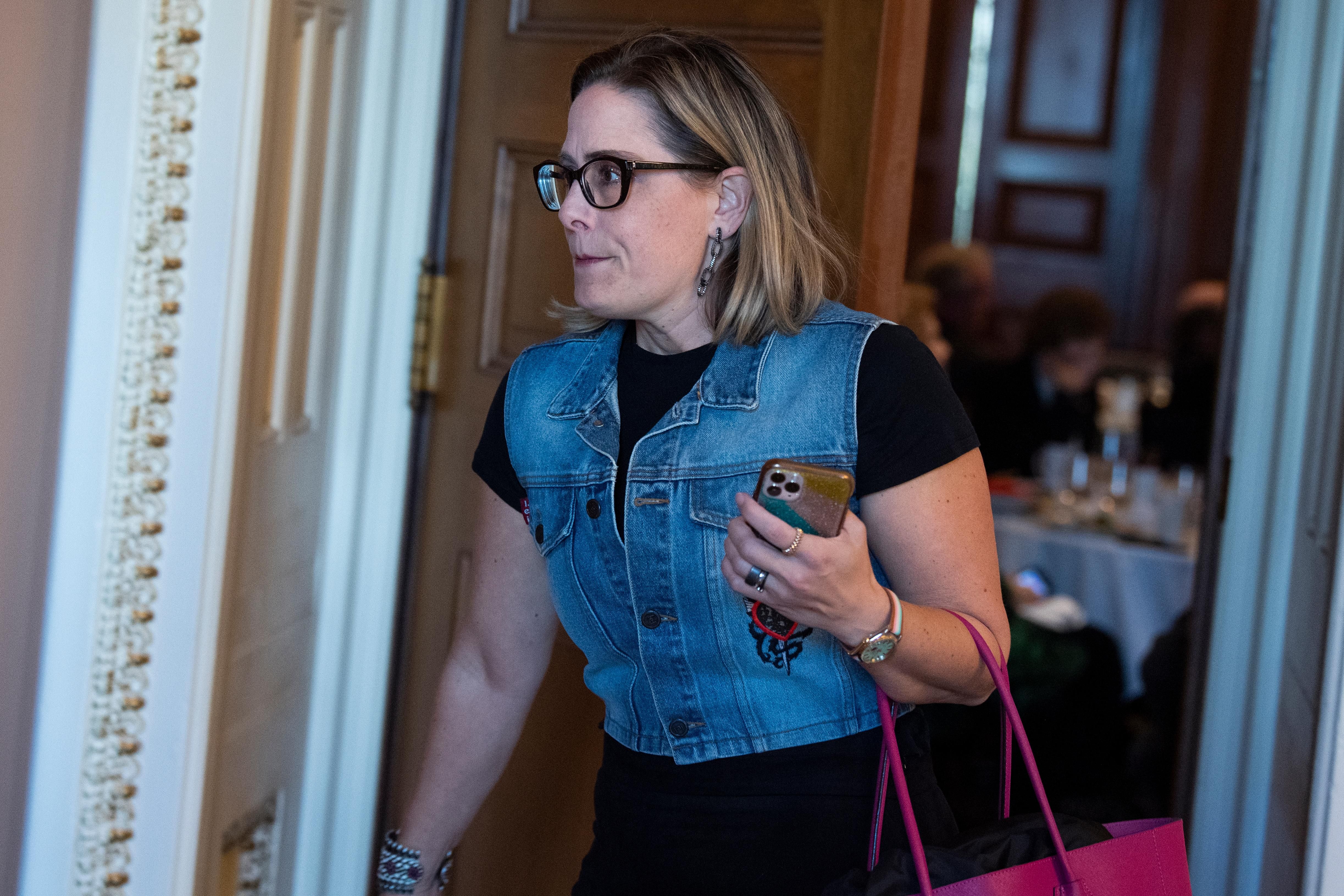 Sen. Kyrsten Sinema leaves a Democratic luncheon