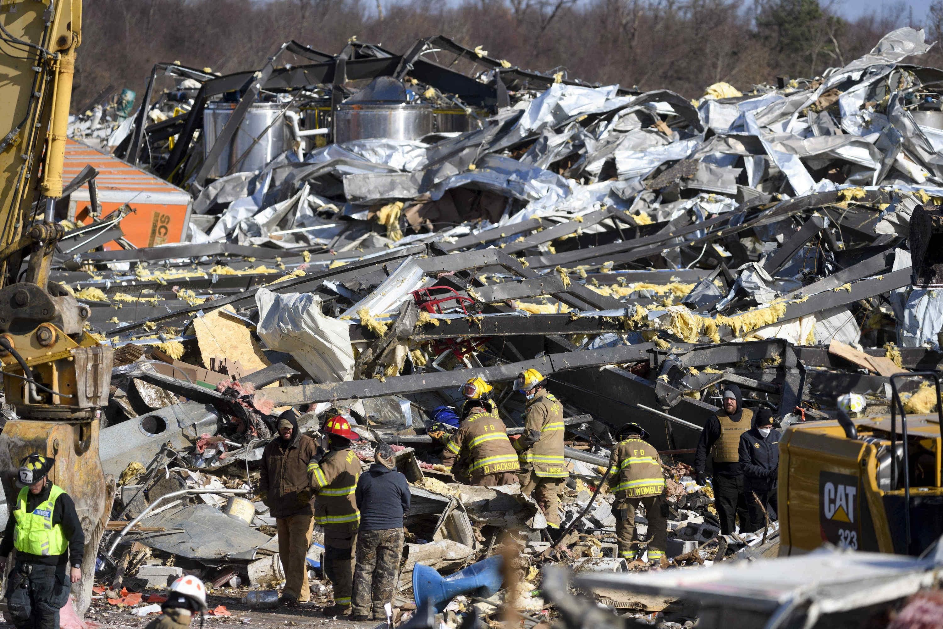 Emergency workers search through what is left of the Mayfield Consumer Products Candle Factory after it was destroyed by a tornado in Mayfield, Kentucky, on December 11, 2021