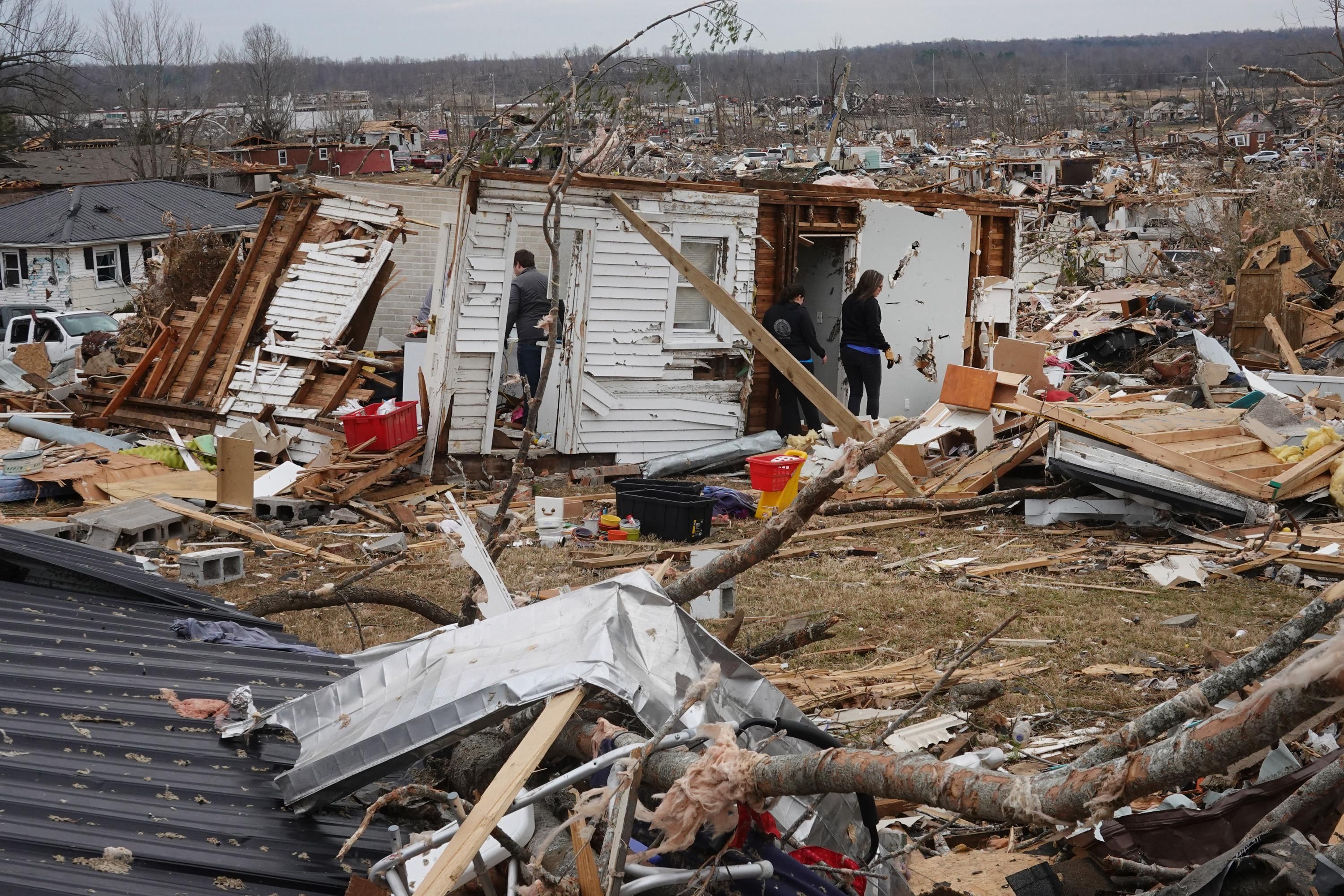 Residents search among the debris of a home after it was destroyed from Friday's tornado on December 15, 2021 in Dawson Springs, Kentucky.