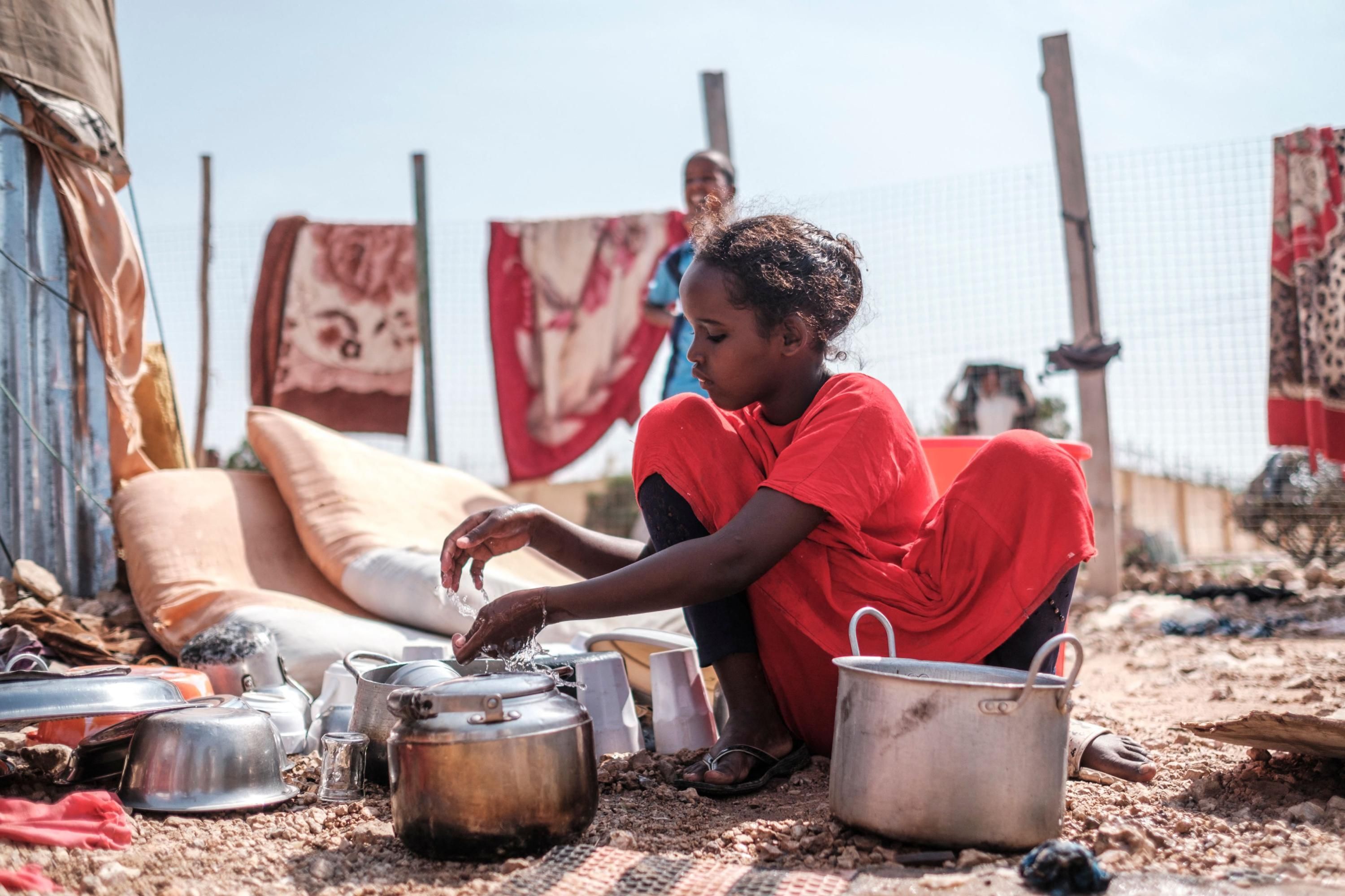A child washing dishes in Somalia