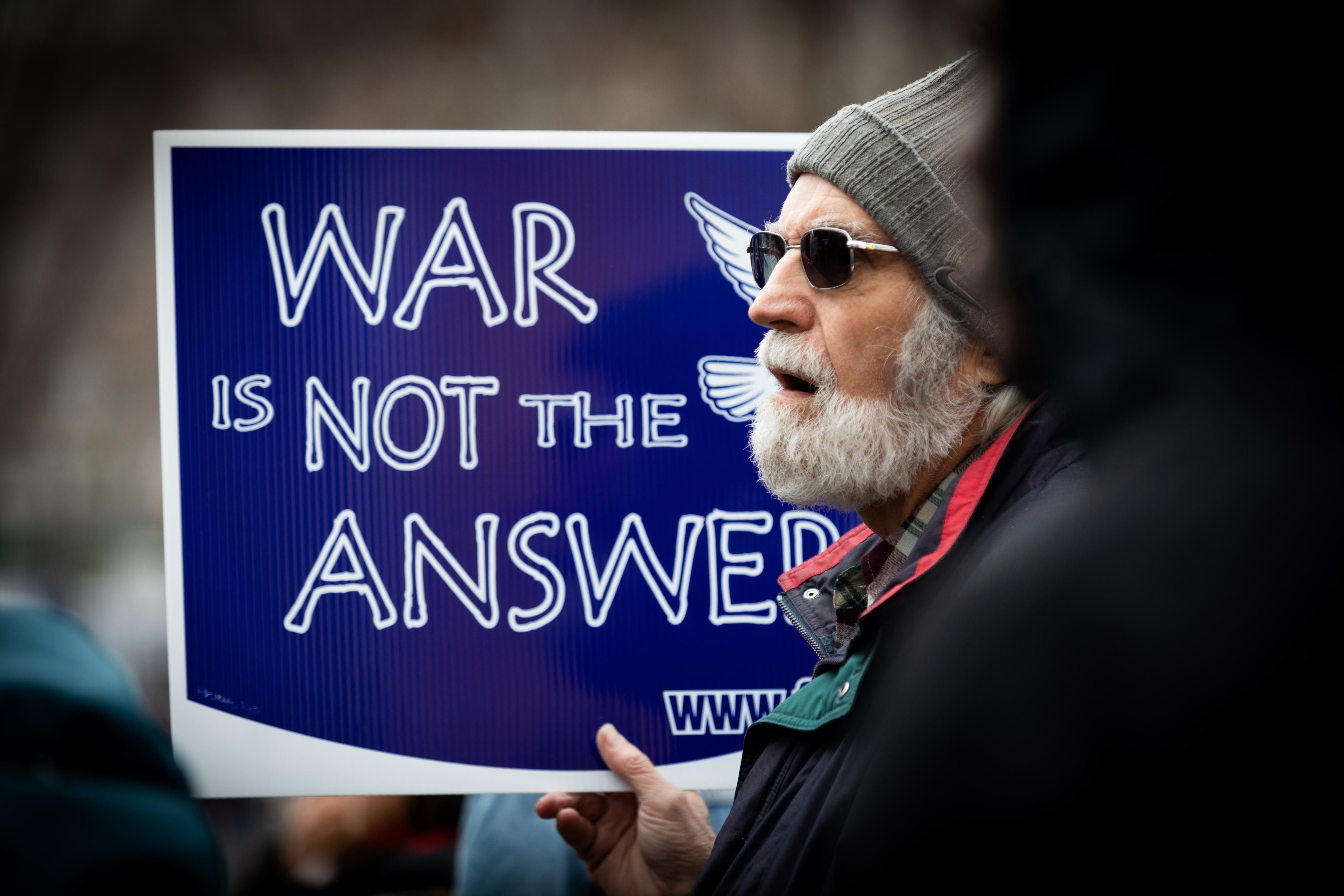 Anti-war protester holds up sign reading "War Is Not the Answer"