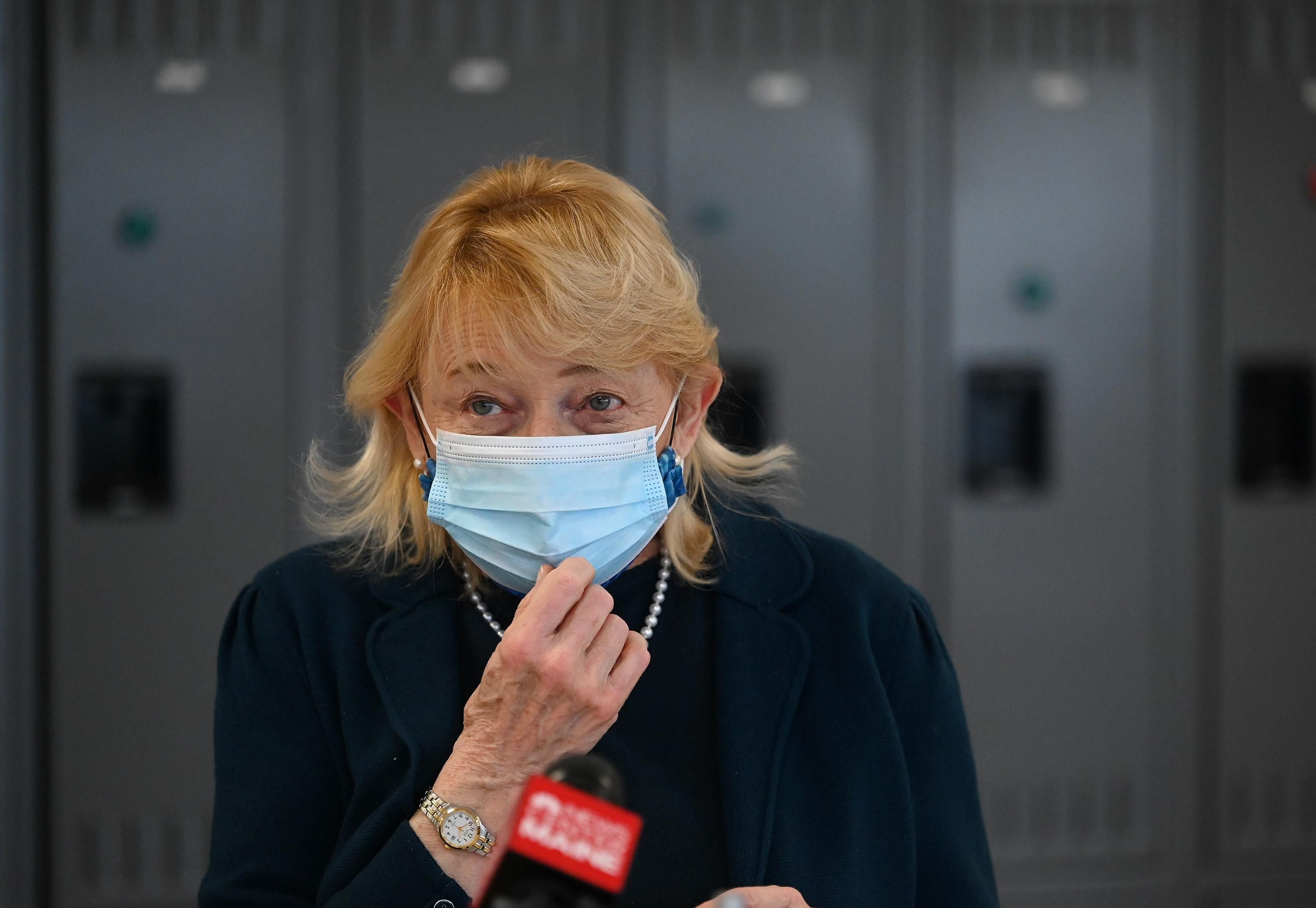 Maine Gov. Janet Mills adjusts her mask as she talks with the press during a visit to MaineHealth's high-volume vaccination clinic at Scarborough Downs on Friday, March 5, 2021.