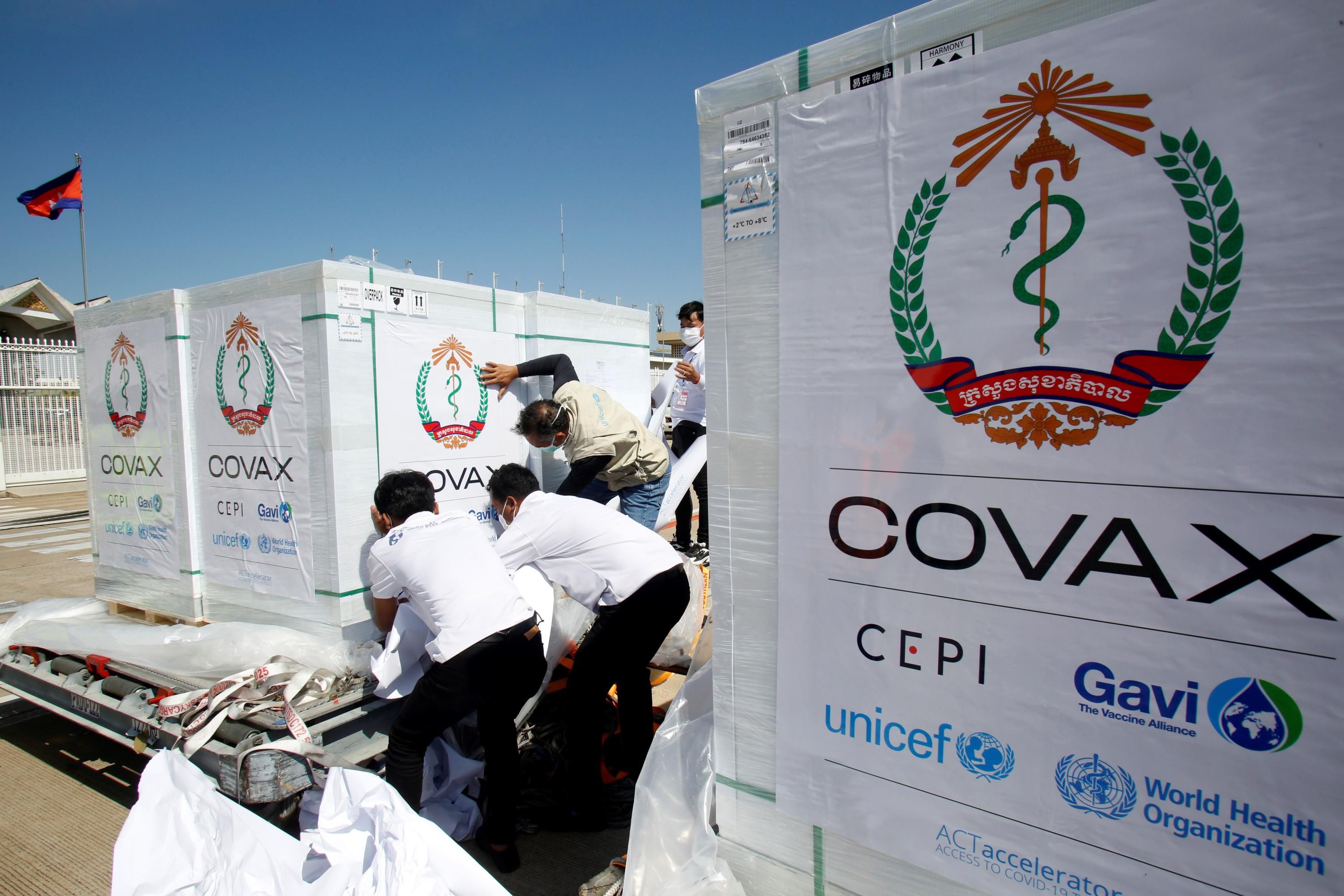 Workers move packages of Covid-19 vaccines
