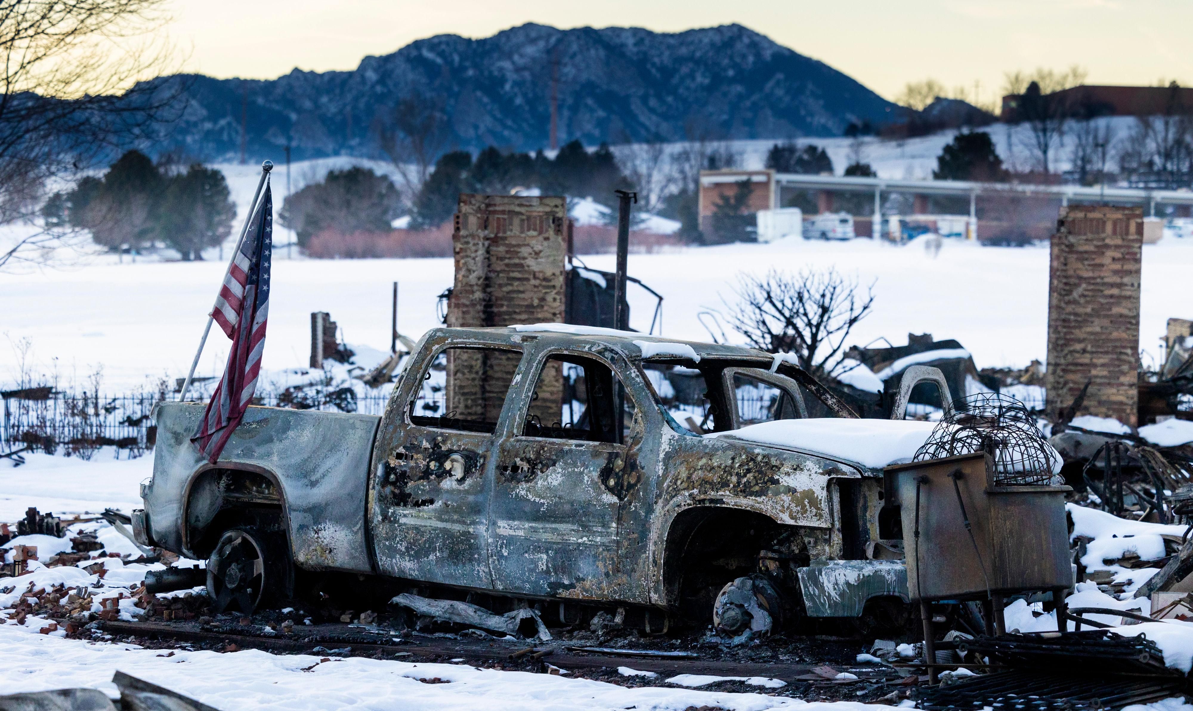An American flag is shown afixed to a burned truck in a neighborhood decimated by the Marshall Fire on January 2, 2022 in Louisville, Colorado