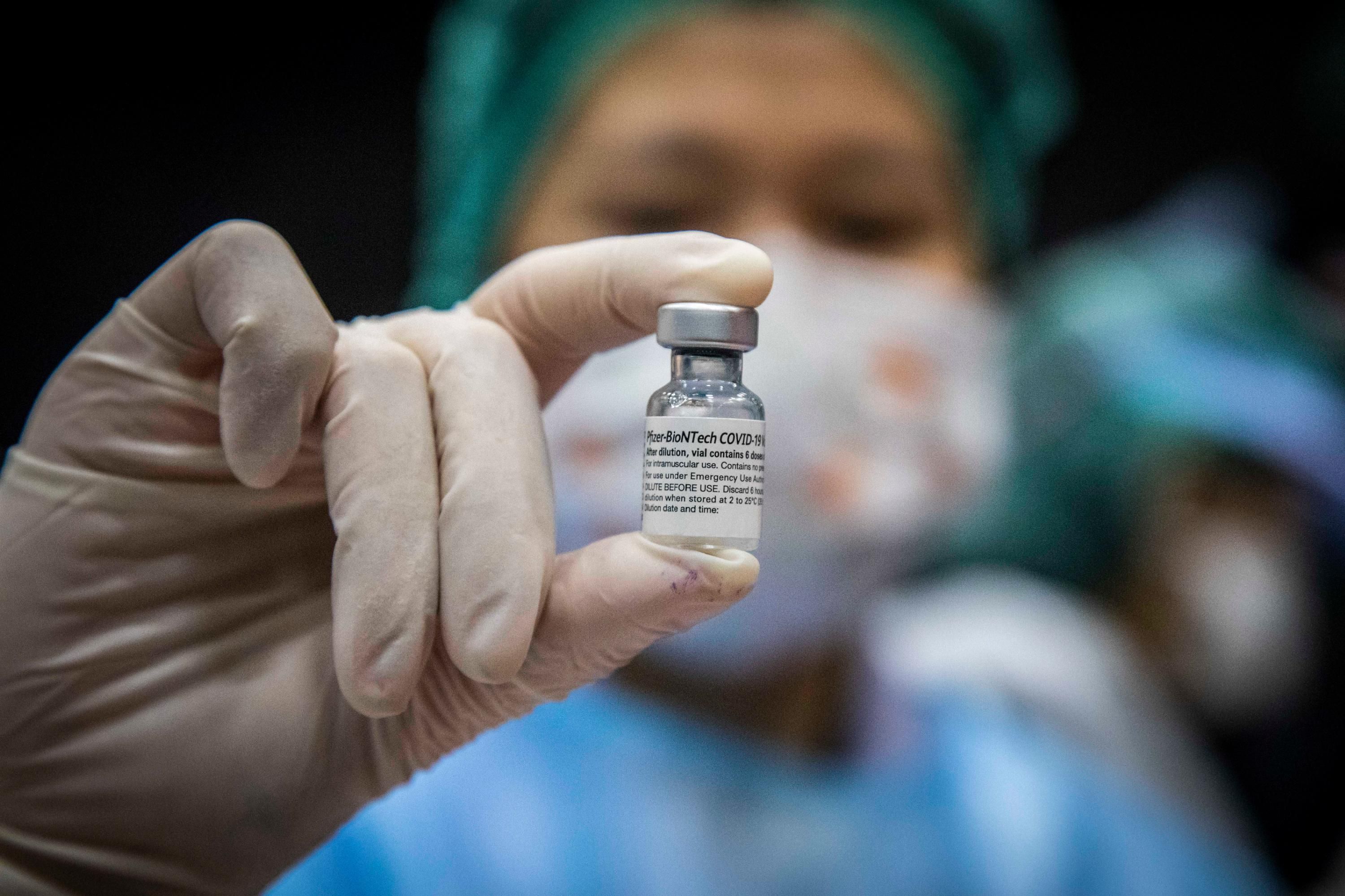 A nurse holds a vial of Pfizer vaccine