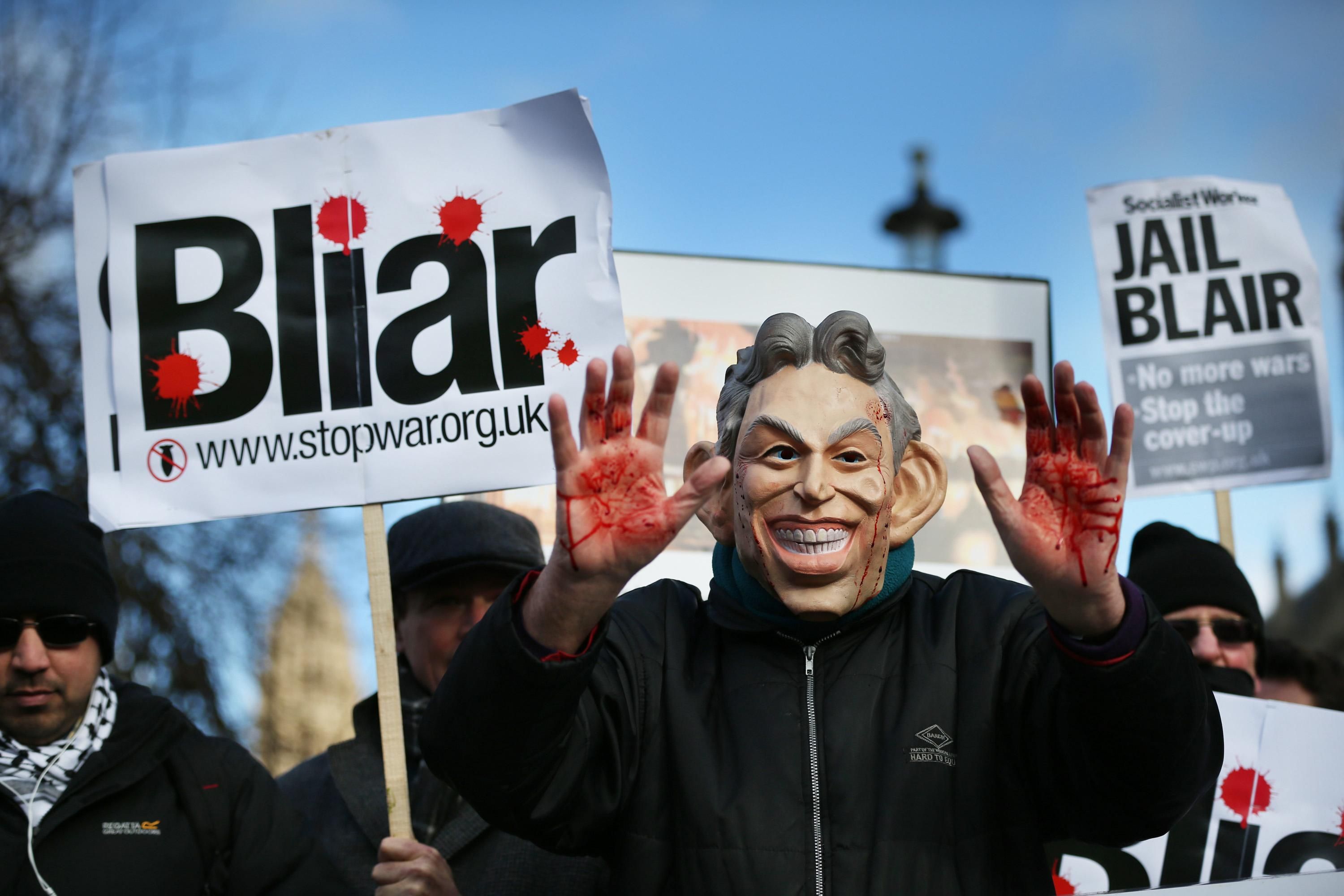 A Stop the War Coalition protester, wearing a mask depicting former Prime Minister Tony Blair, shows bloodied hands near Parliament on January 29, 2015 in London. 