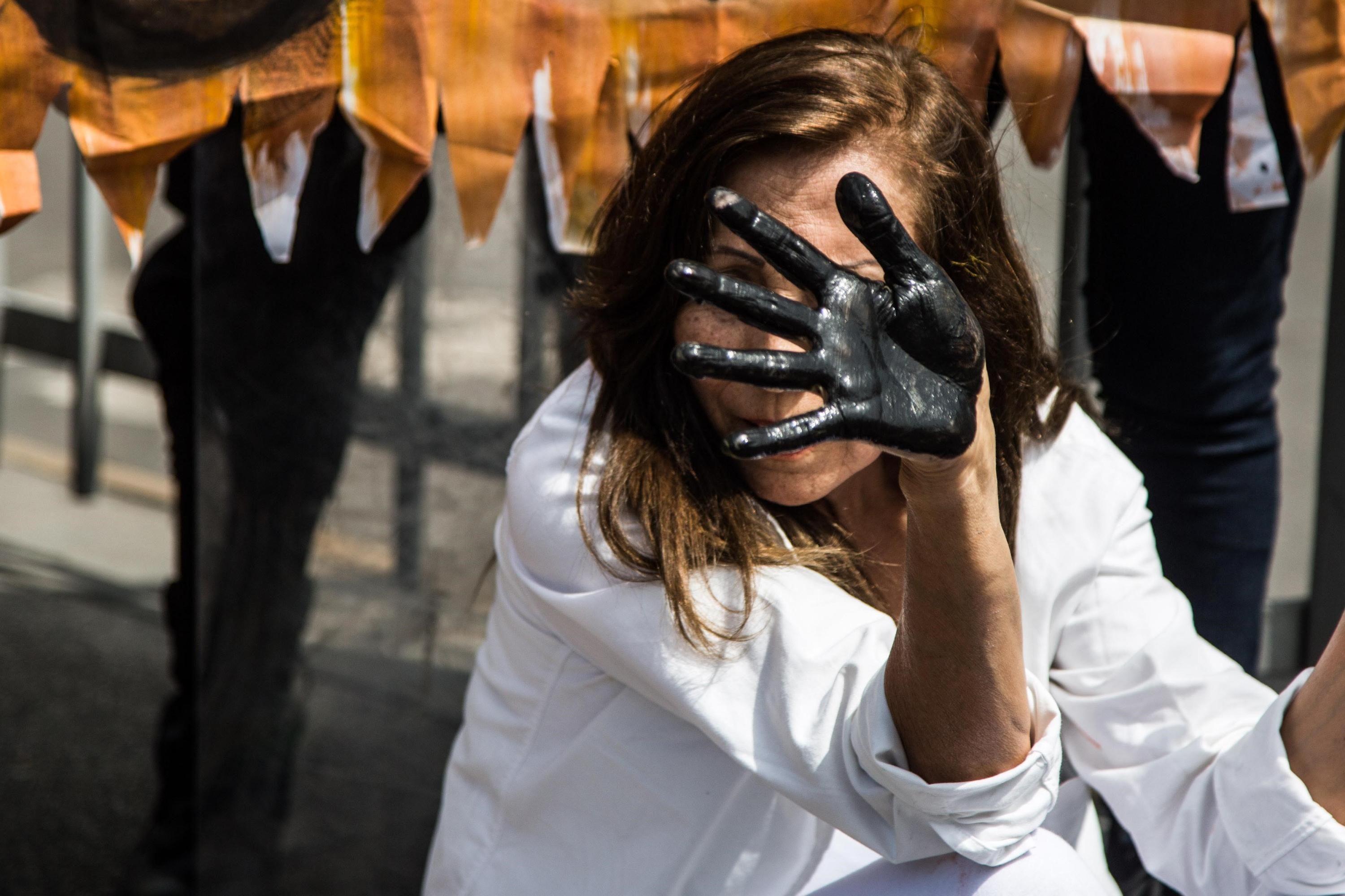 A woman displays oil on her hands at a protest