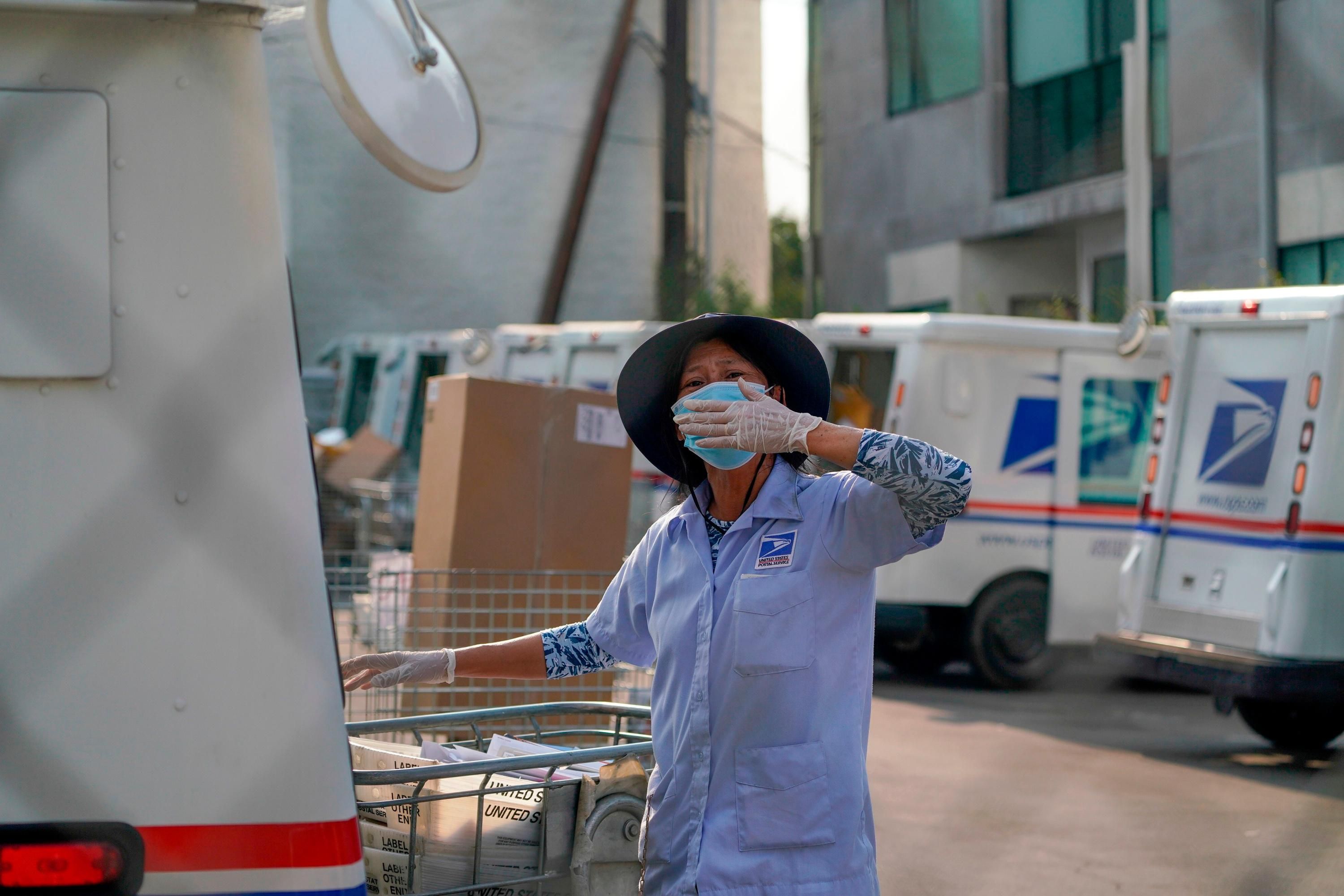 A postal worker blows a kiss to demonstrators