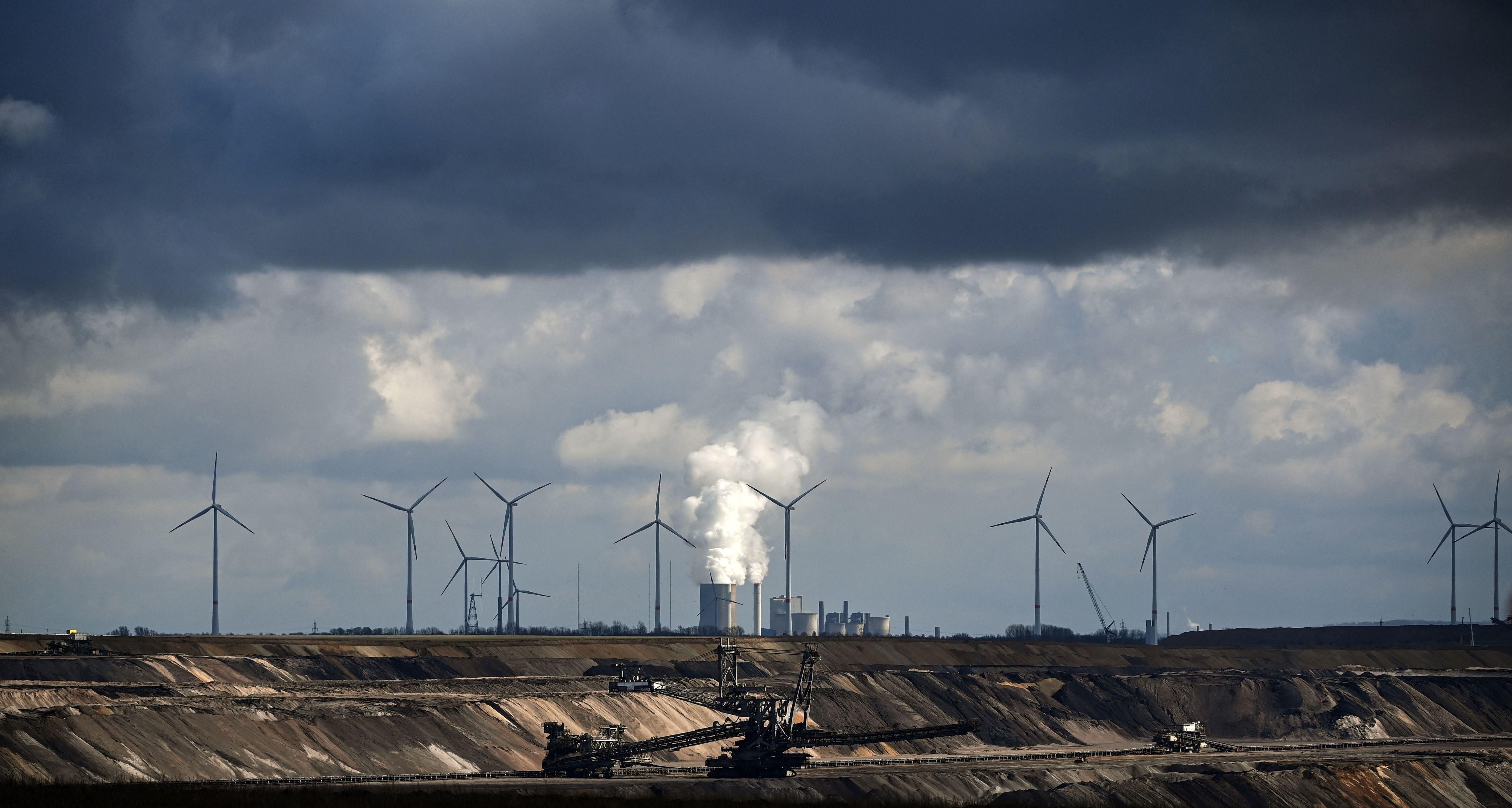 In Garzweiler, Germany, wind turbines are seen near an open-cast mining operation and a coal-fired power plant run by German energy giant RWE on March 15, 2021.