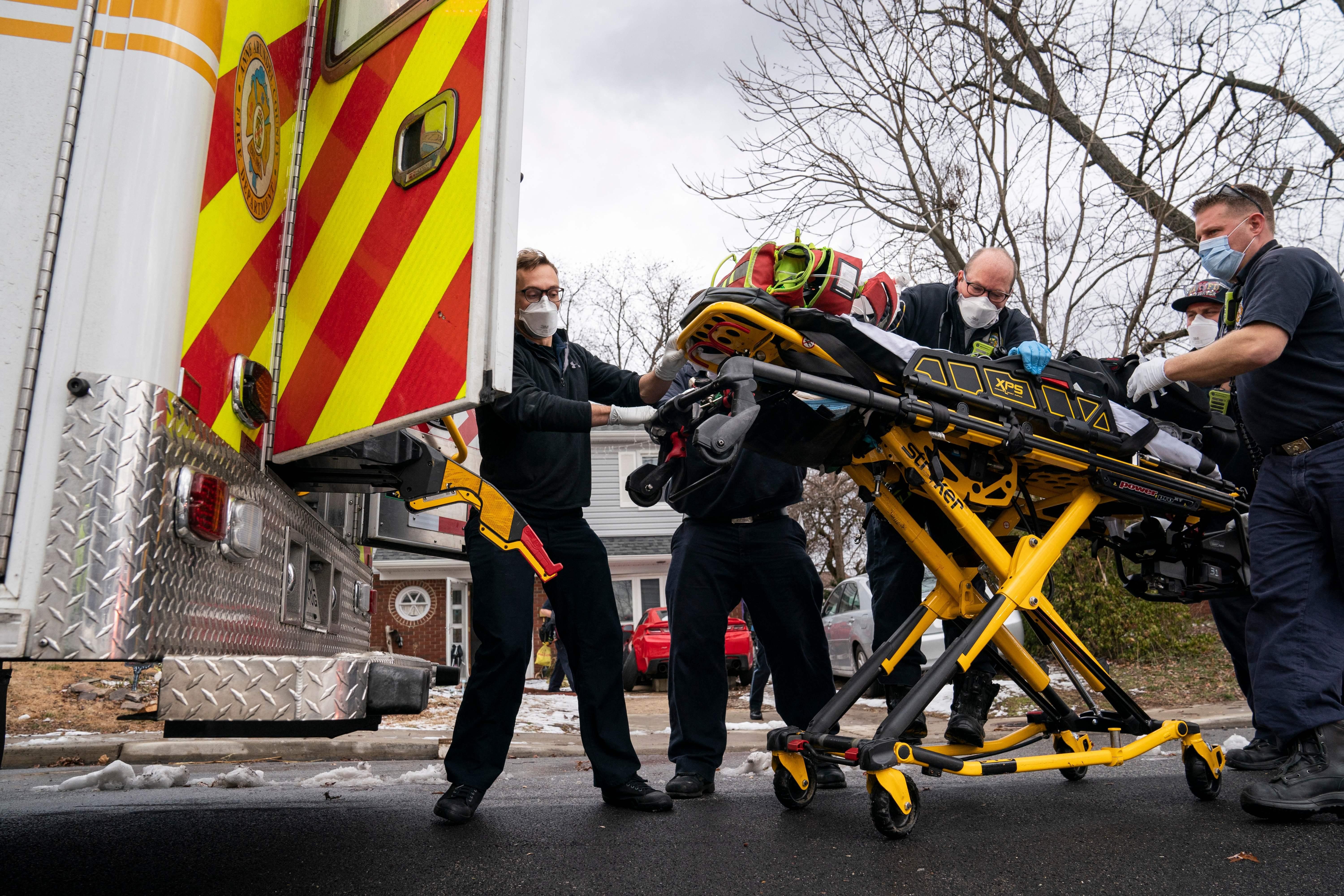 Firefighters and paramedics with Anne Arundel County Fire Department load a pediatric Covid-19 patient who is in cardiac arrest into an ambulance after responding to a 911 emergency call on January 17, 2022, in Glen Burnie, Maryland. 