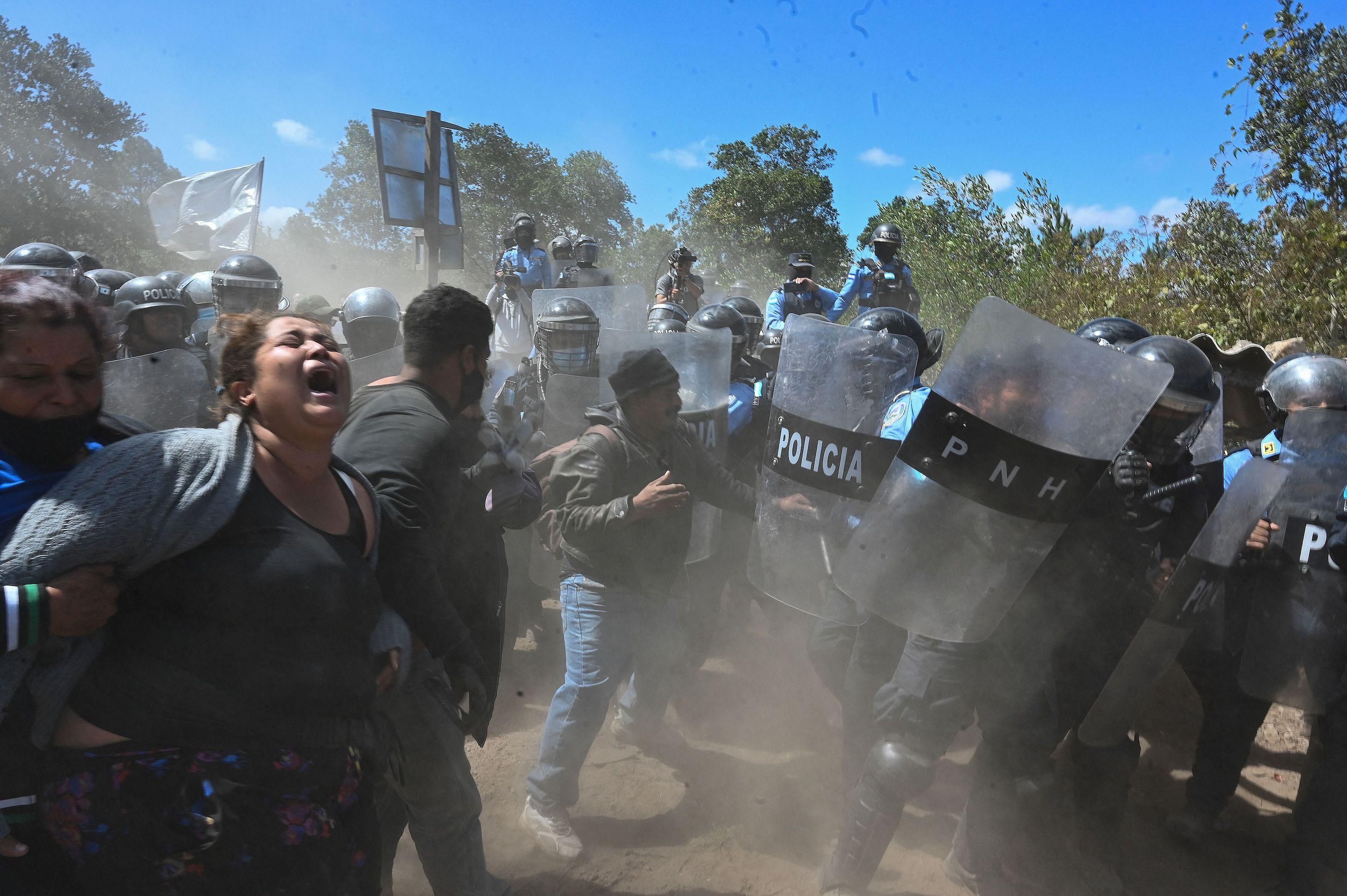 Residents face riot police during an attempted eviction at Tierras del Padre, a Lenca Indigenous community between the municipalities of Ojojona and San Buenaventura, Francisco Morazan department, Honduras, on February 9, 2022. 