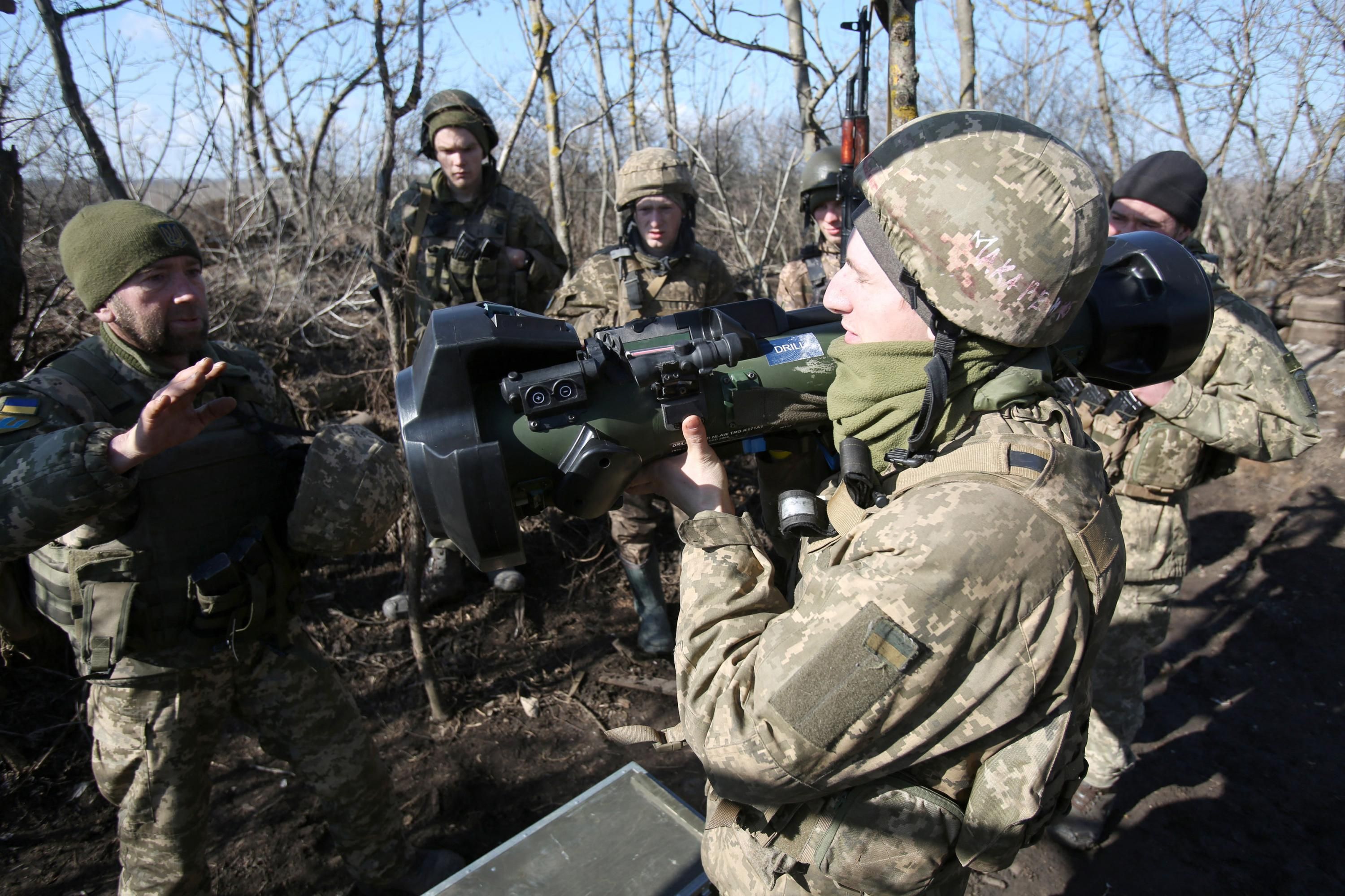 Ukrainian soldiers examine an anti-tank missile