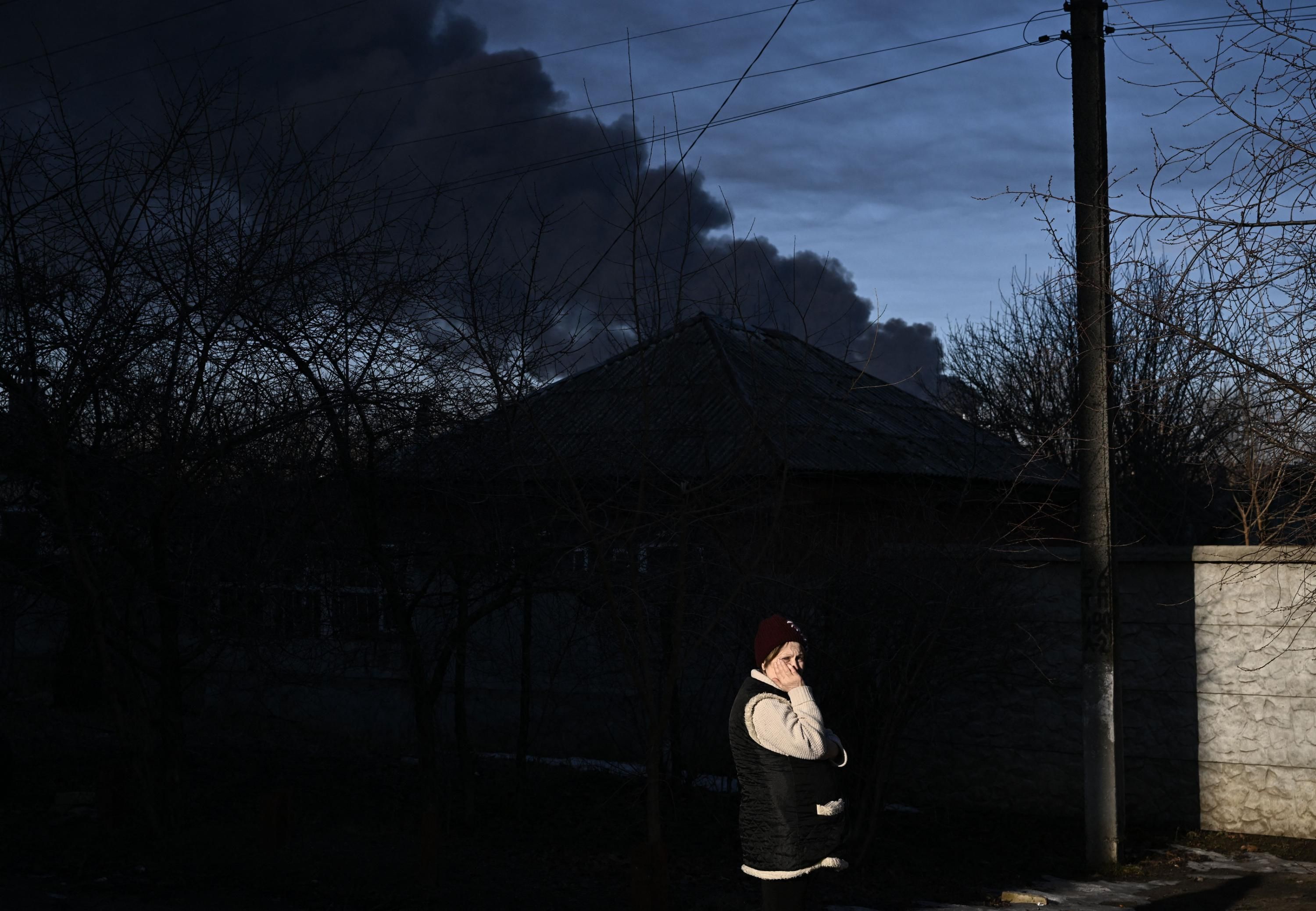 A woman looks on as Russia launches its attack on Ukraine