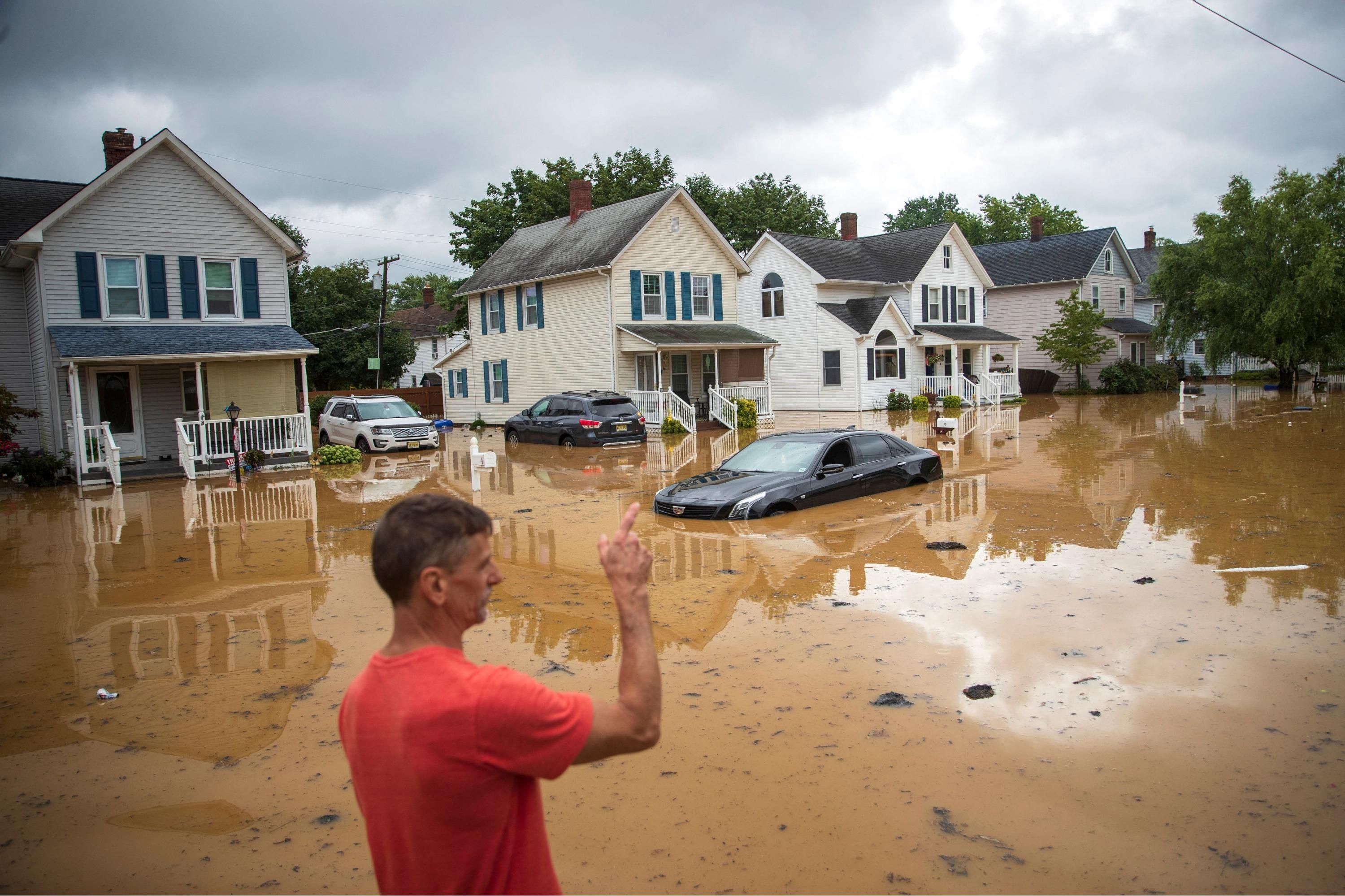An evacuated resident points in the direction of his home following a flash flood, which came as Tropical Storm Henri made landfall, in Helmetta, New Jersey on August 22, 2021.