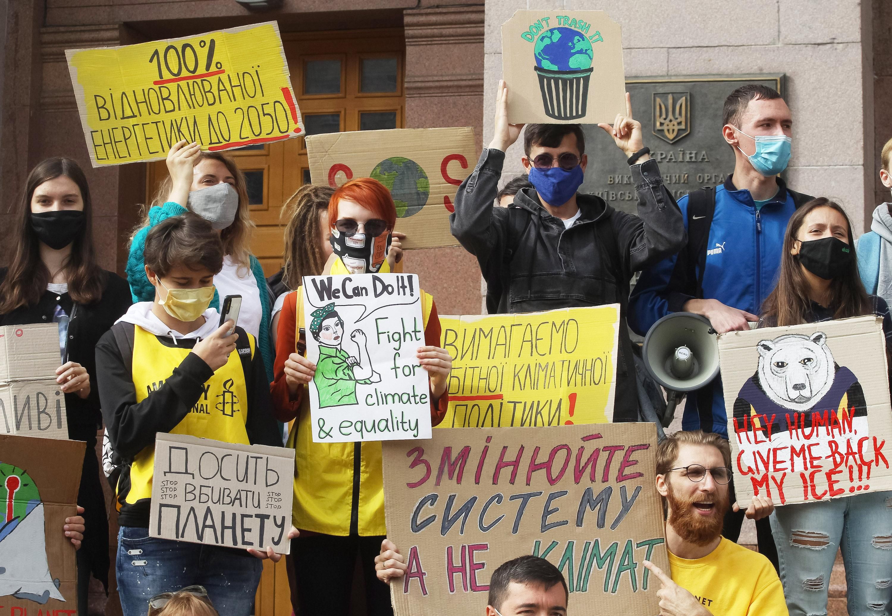 Climate protesters with the Fridays for Future movement hold placards during a demonstration outside City Hall in Kiev, Ukraine on Sept. 25, 2020. 