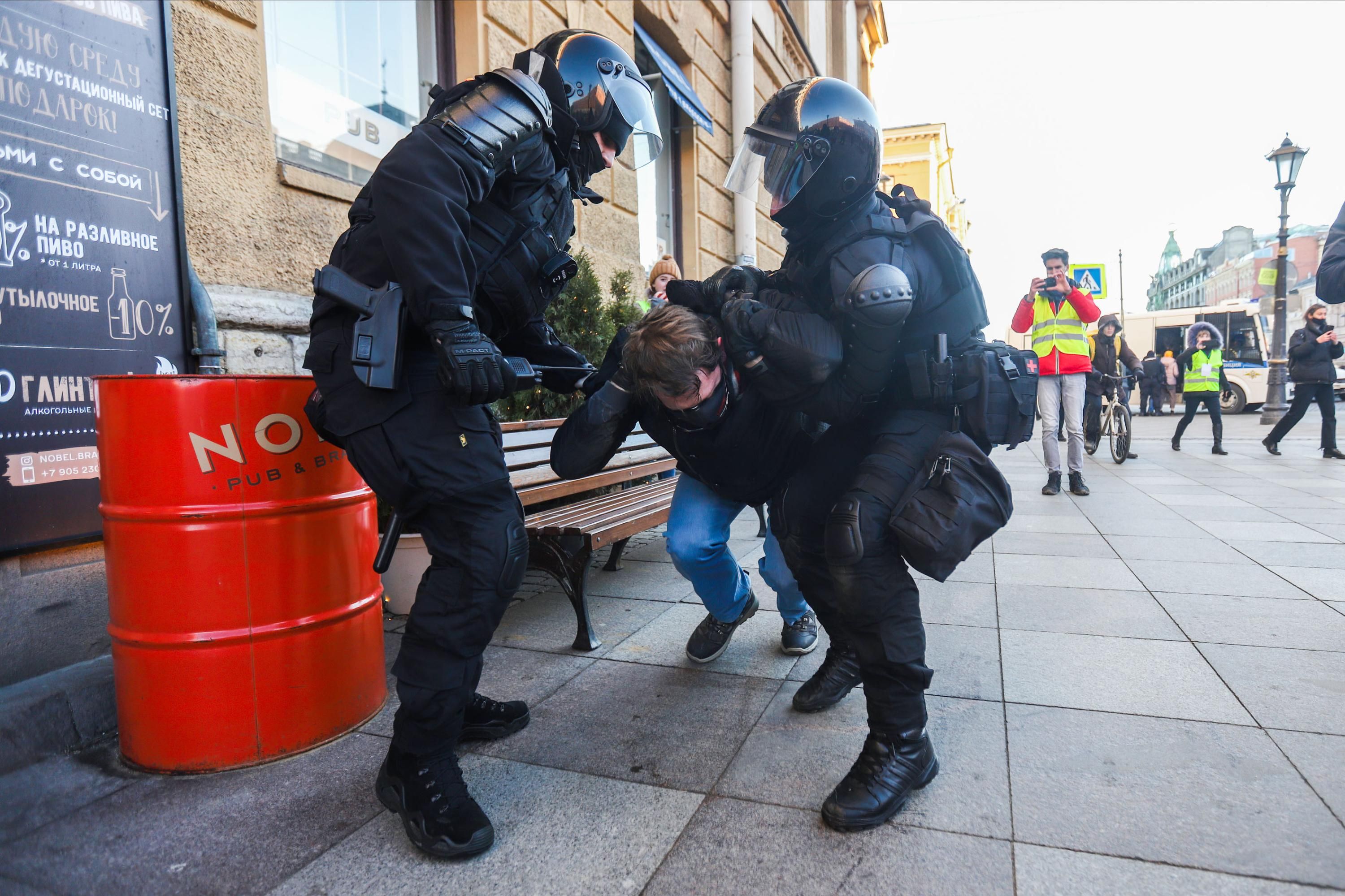 Russian police officers detain a protester